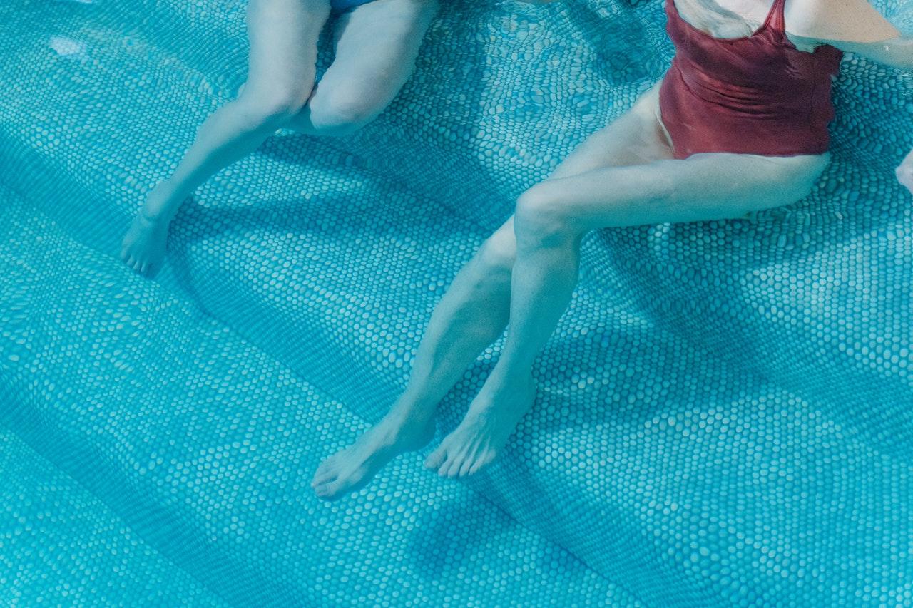 pernas de duas pessoas na agua