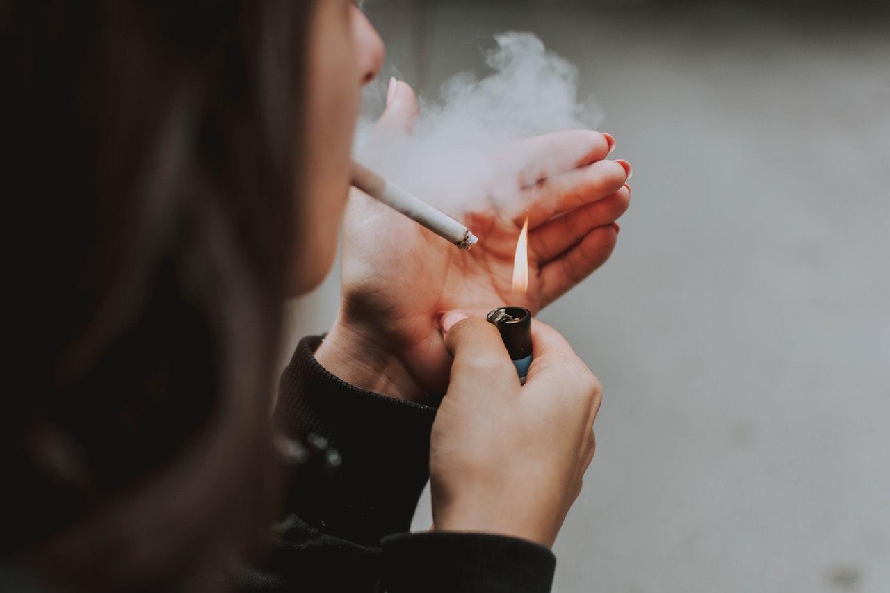 pessoa a acender cigarro
