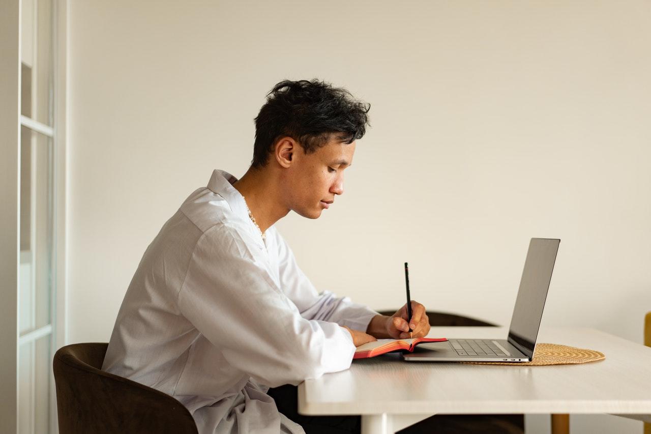 aluno a tirar notas com computador