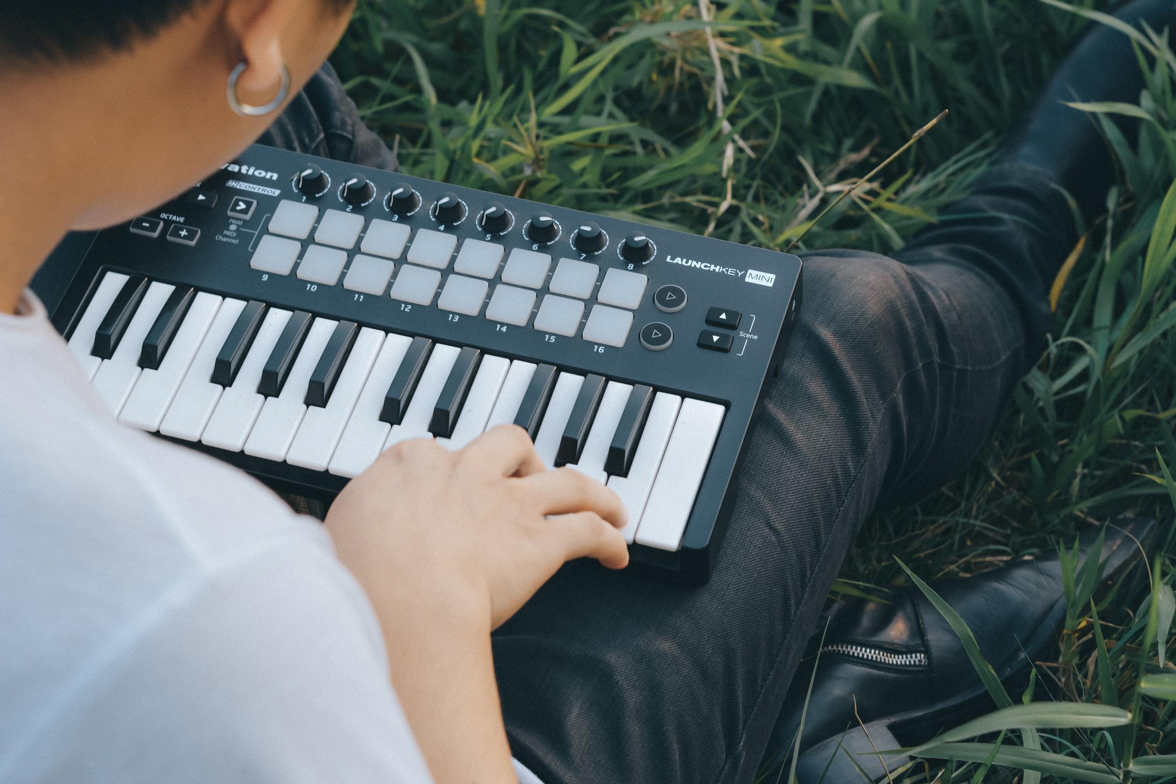 Mãos femininas a tocar um piano na relva