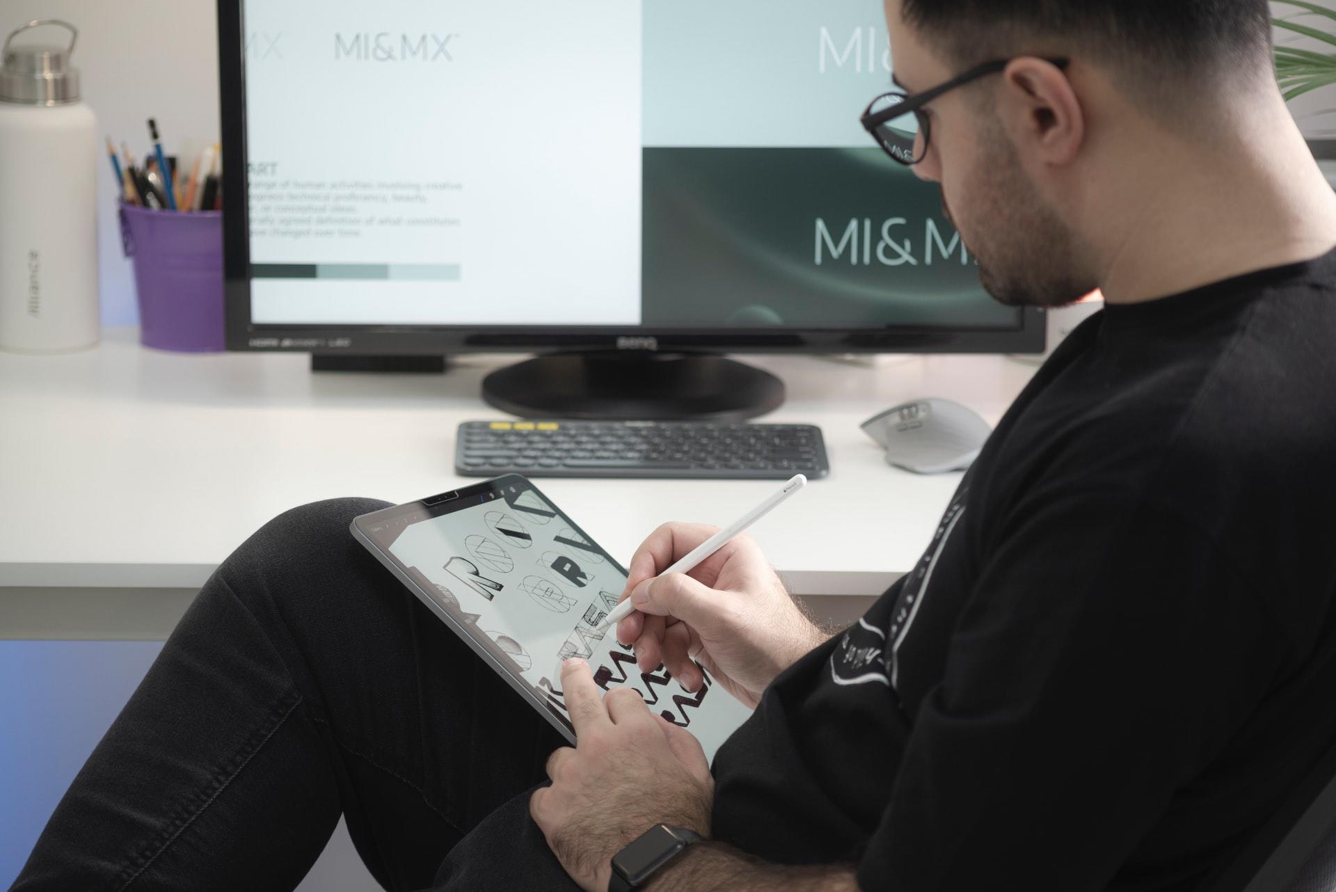 Homem sentado a desenhar no tablet