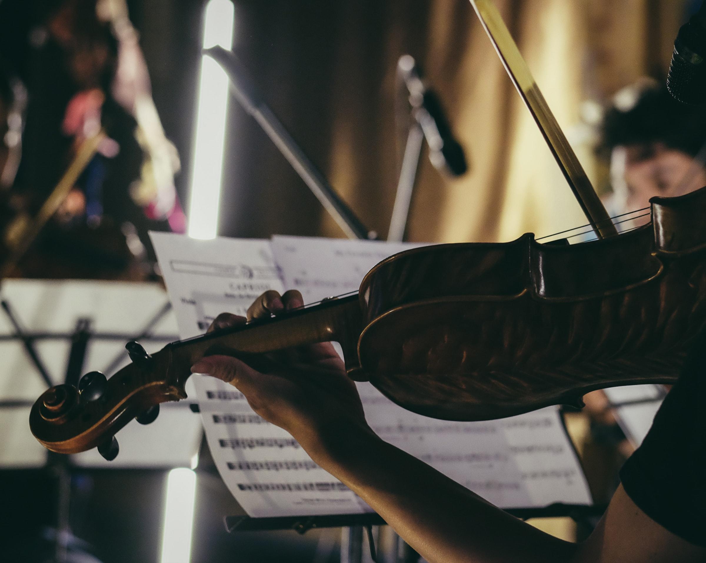 mãos femininas com violino e pauta