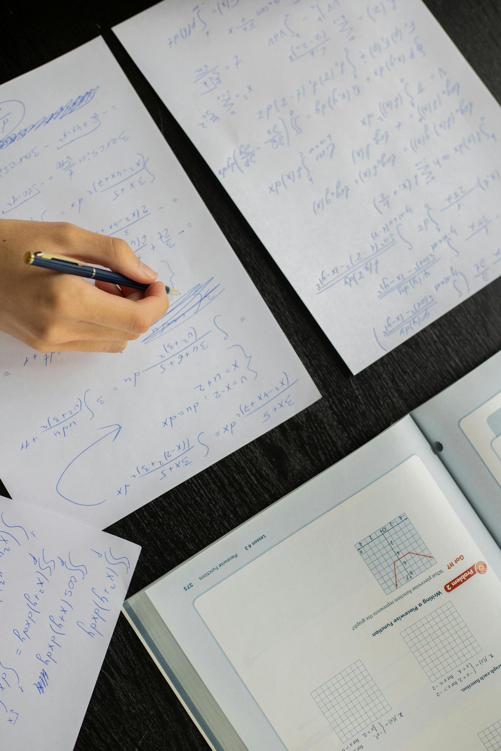 livros e folhas com calculos de matemática