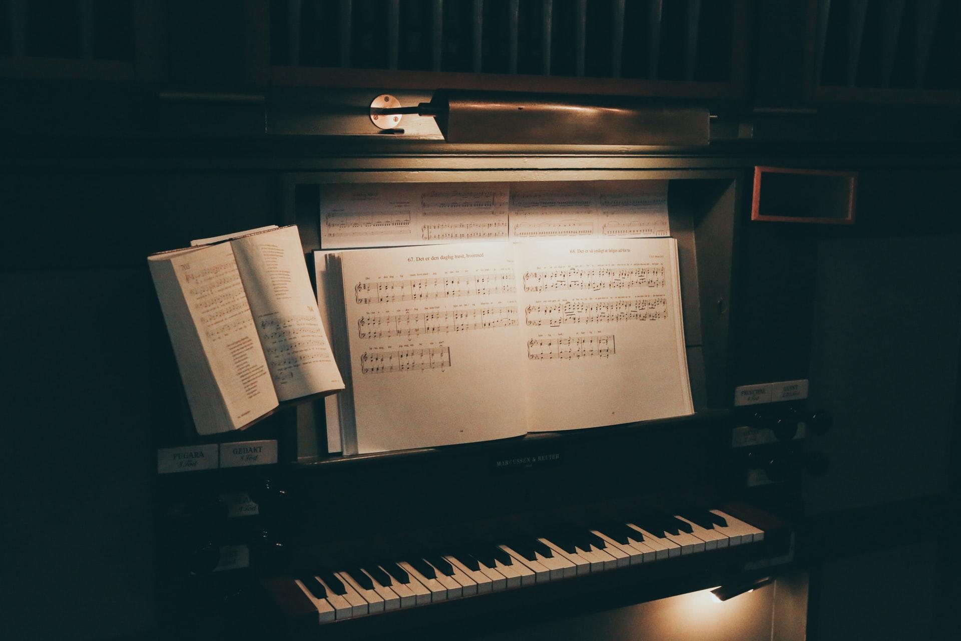 Piano à noite iluminado com várias pautas