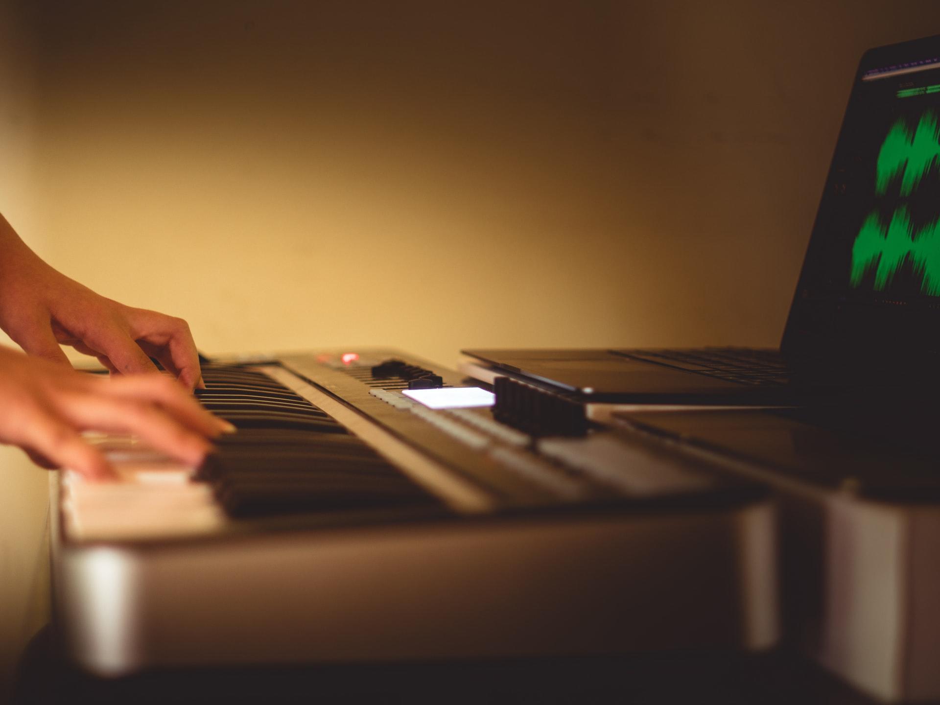 Piano em destaque e mãos a tocar