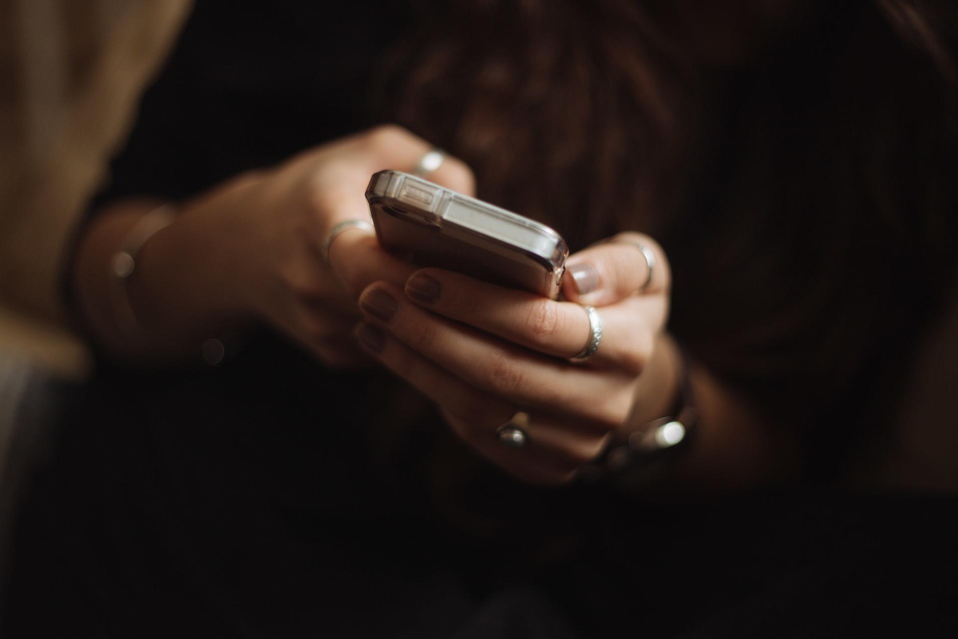 mãos femininas com telemóvel