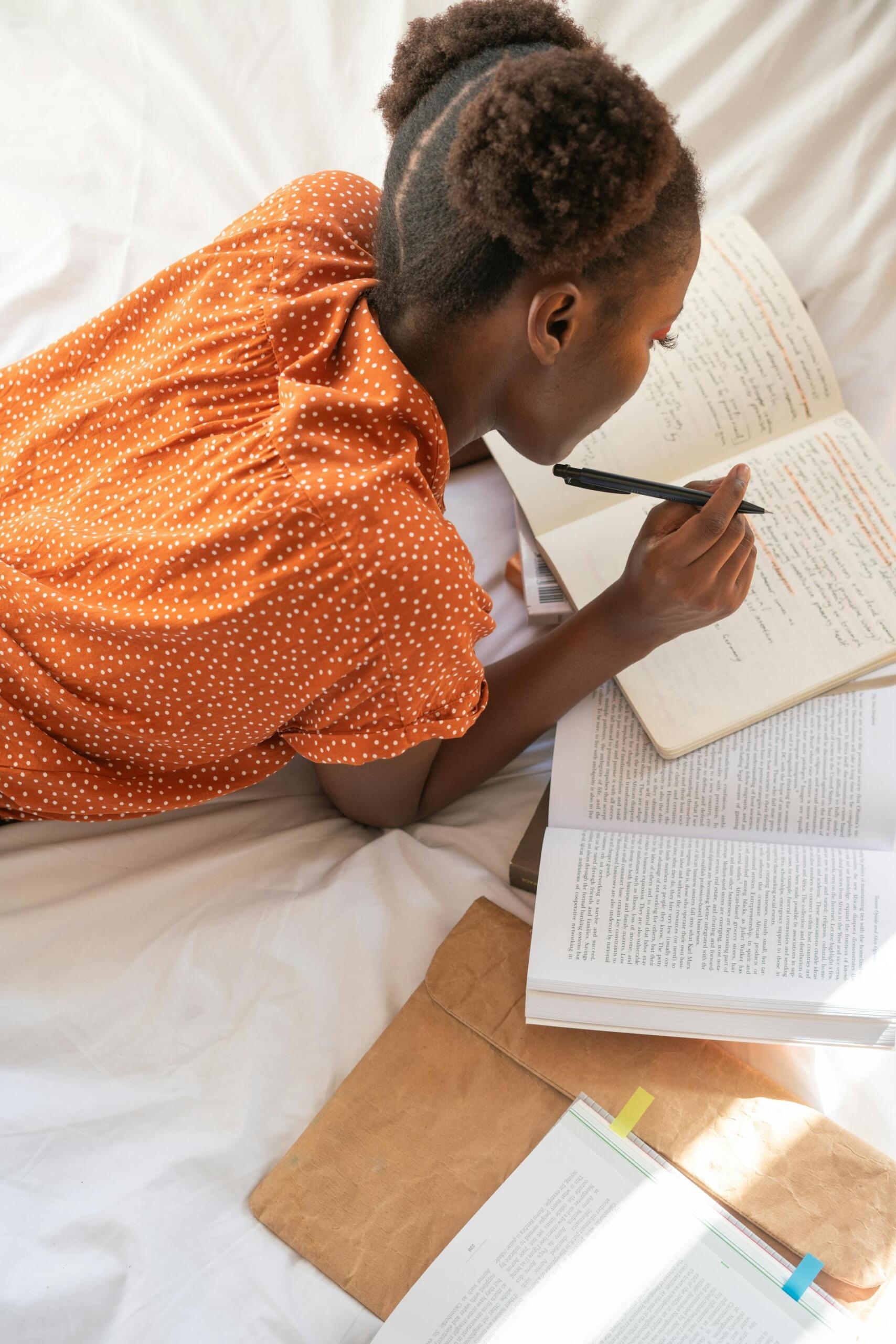 aluna e estudar na cama com livros e caneta