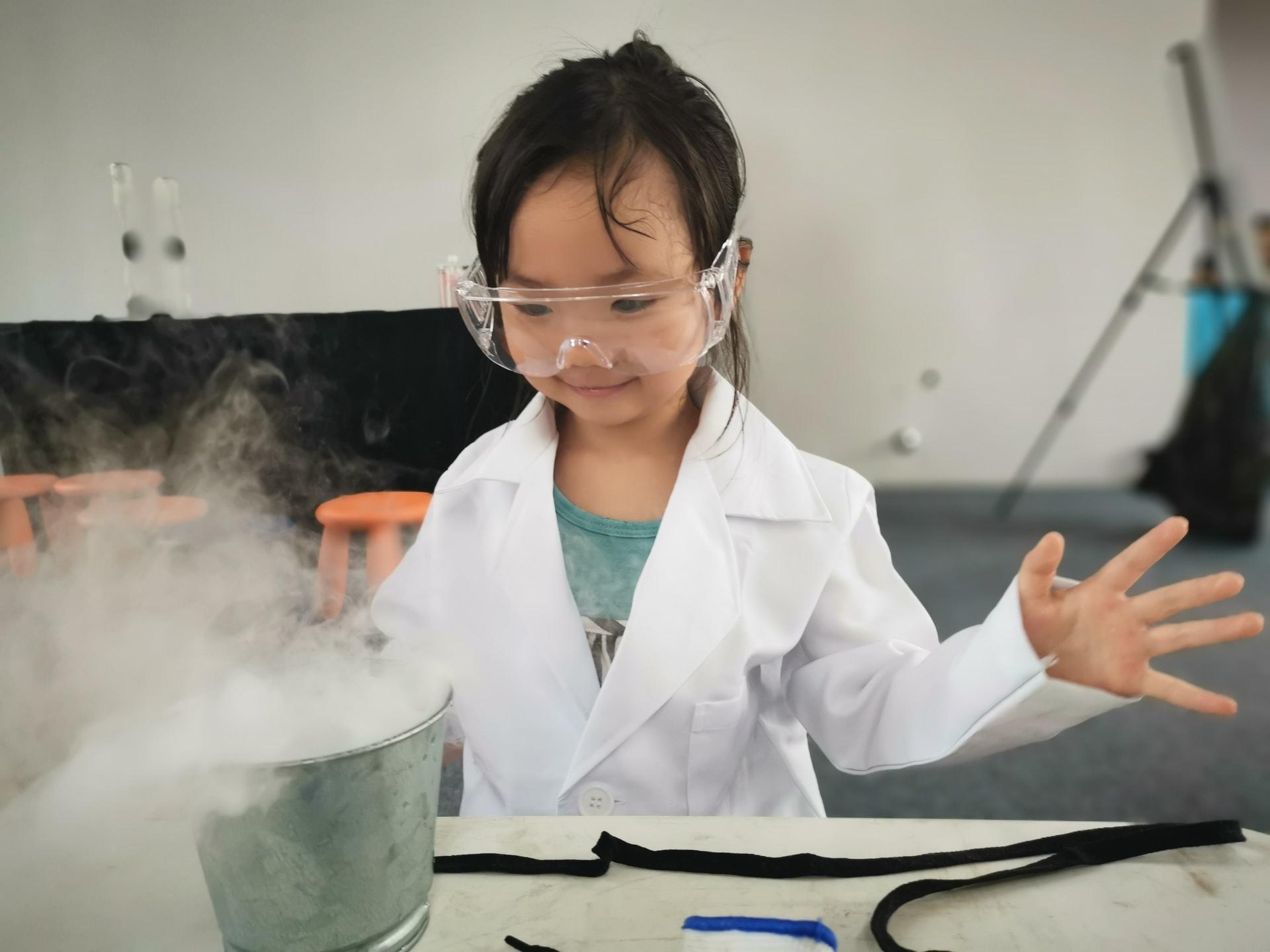 Criança vestida de cientista a brincar