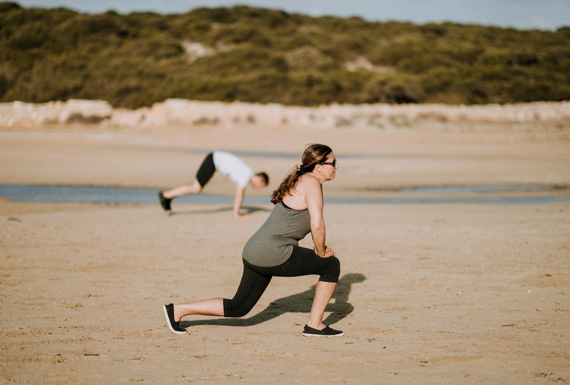 Mulher na praia a realizar um lunge