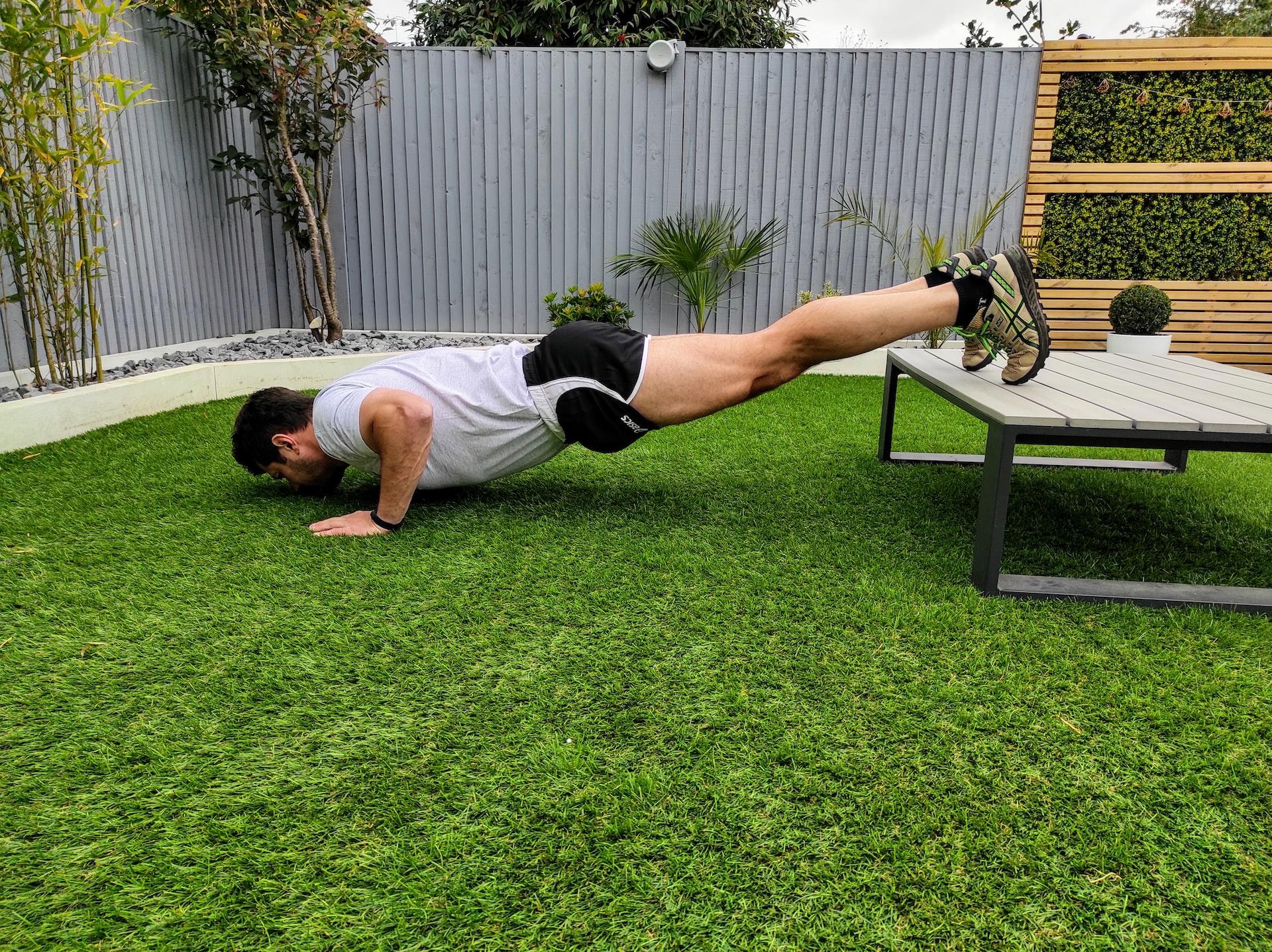 Homem a realizar uma flexão no exterior