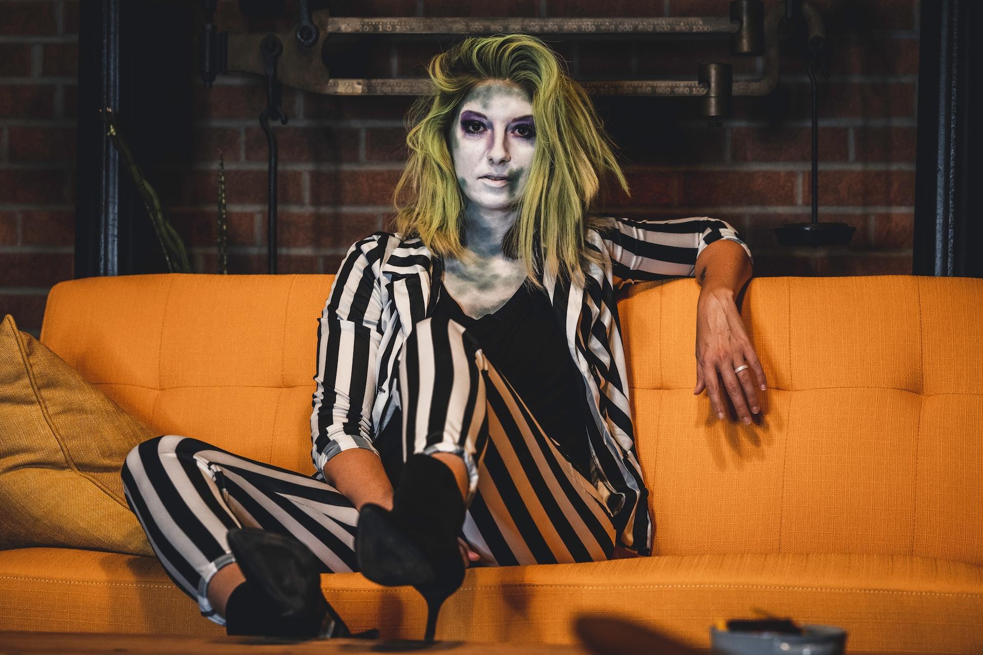 Mulher disfarçada de Halloween num sofá