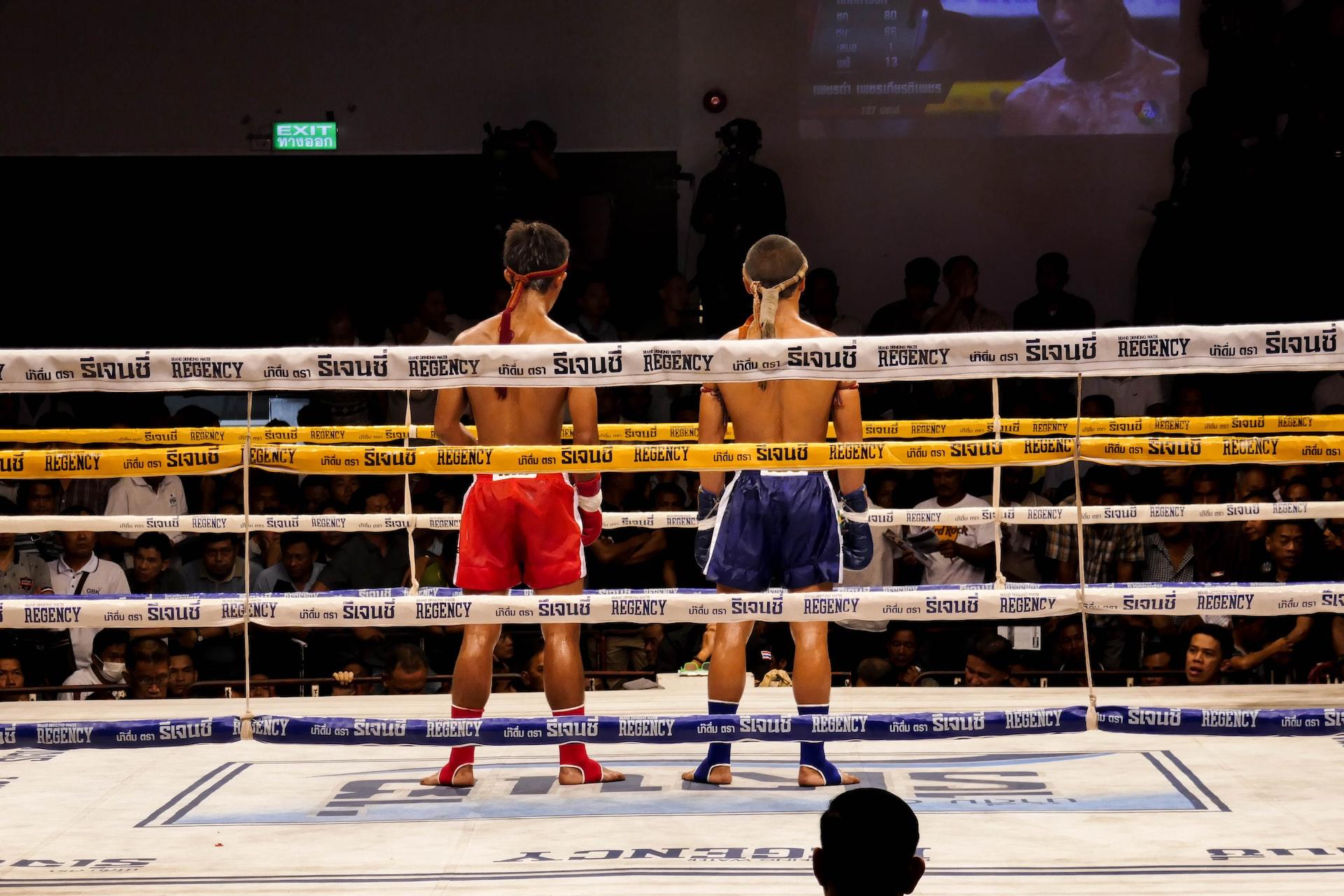 Dois atletas de boxe de costas num ringue