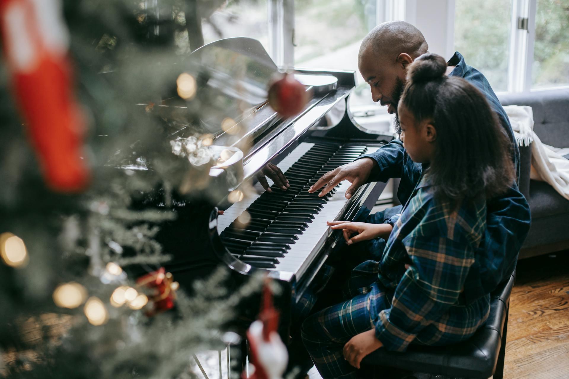 pai e filha em frente a um piano