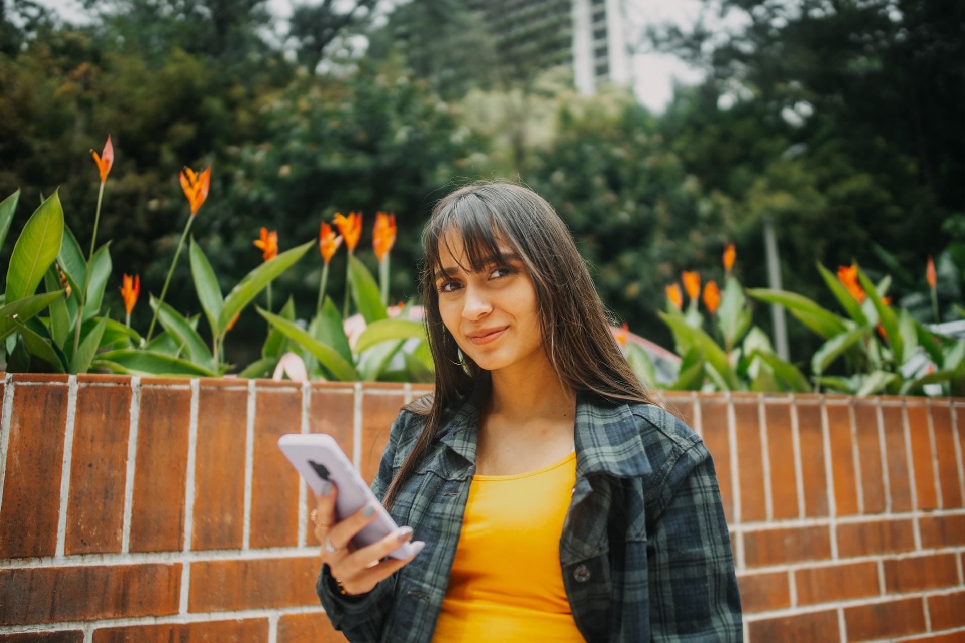 Mulher com telemóvel nas mãos a resolver exercícios de química