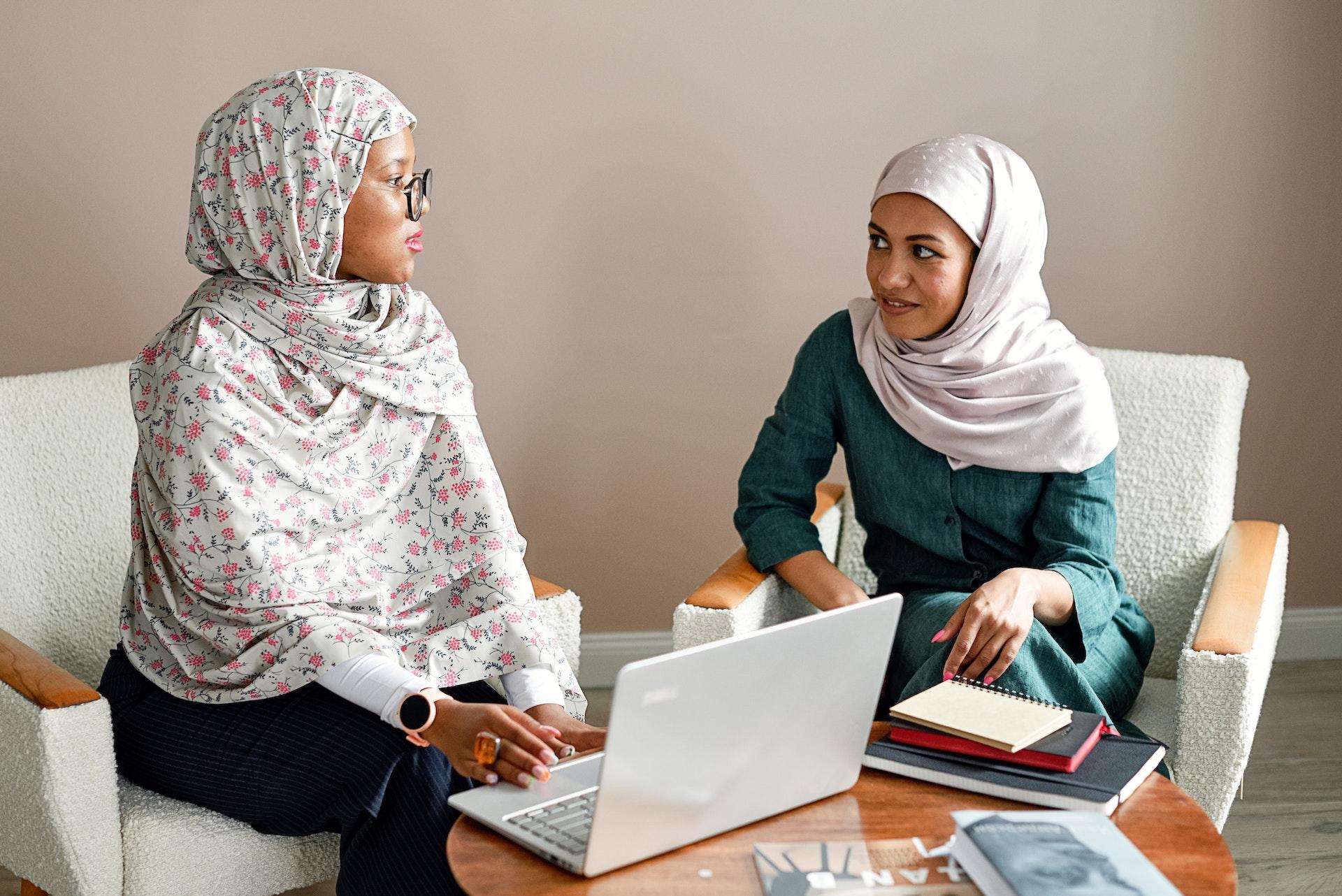 duas mulheres a conversar com um computador