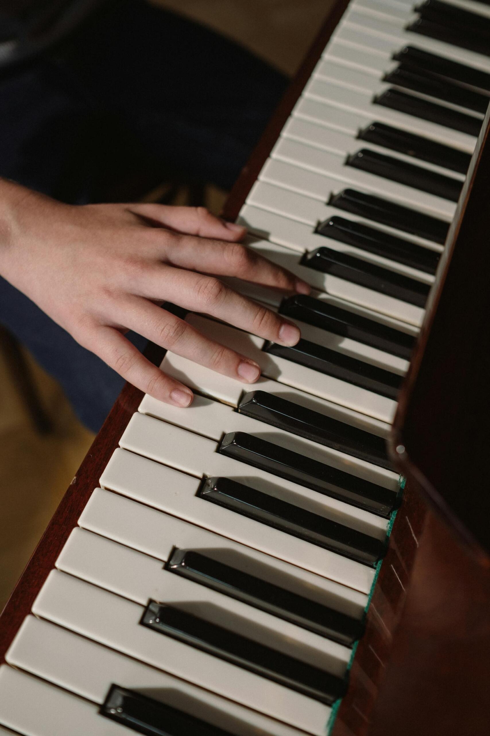 mão de pessoa a tocar piano