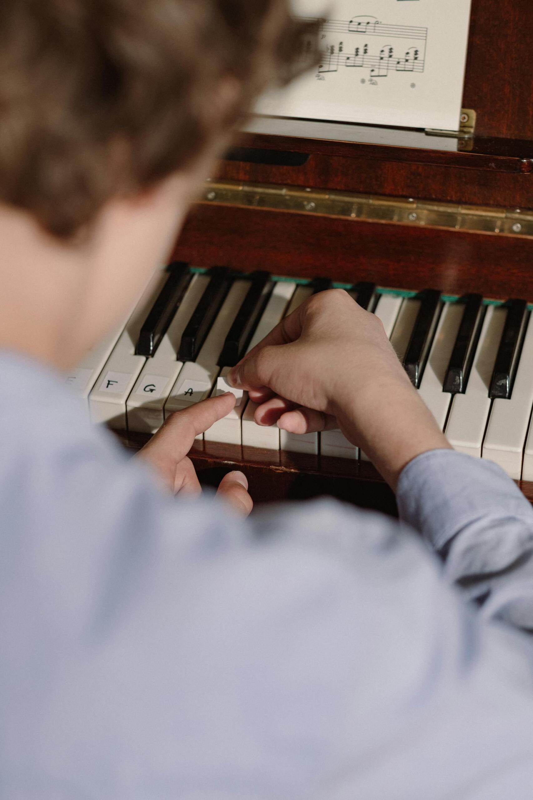 pessoa a colar as notas em teclas de piano