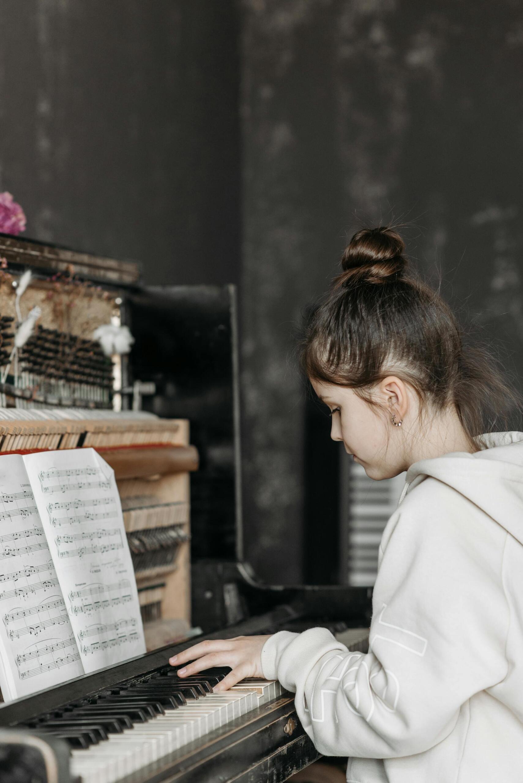 menina de cabelo apanhado a tocar piano