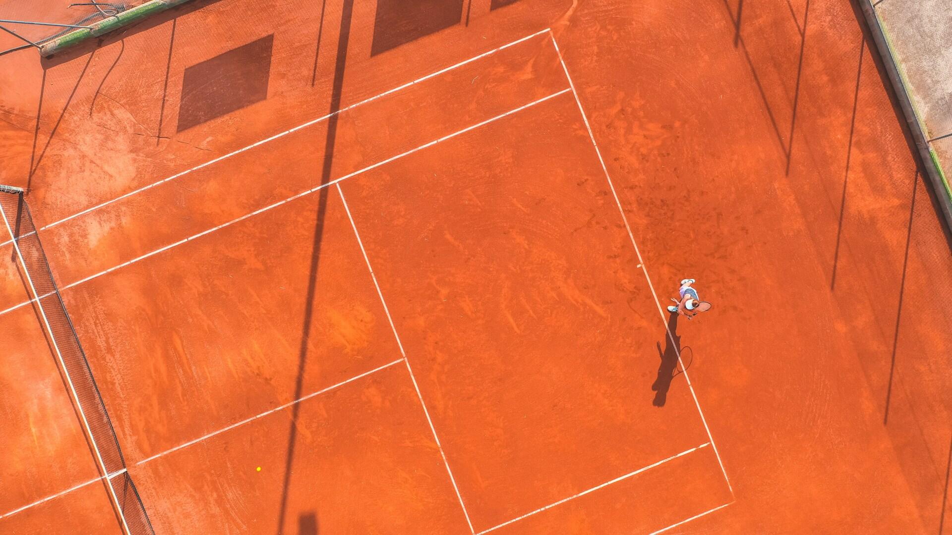 Mulher a jogar num terreno de terra batida