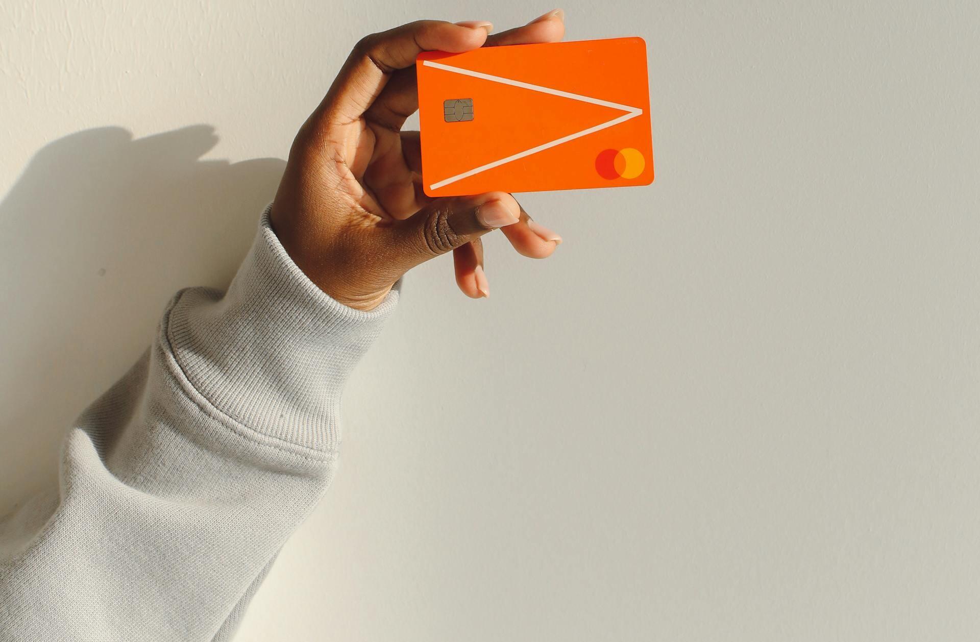 pessoa a segurar em cartão multibanco