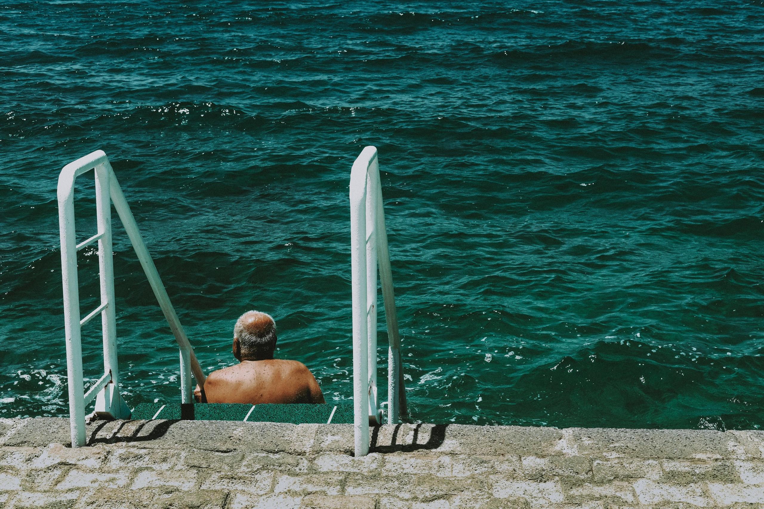 homem idoso dentro de agua
