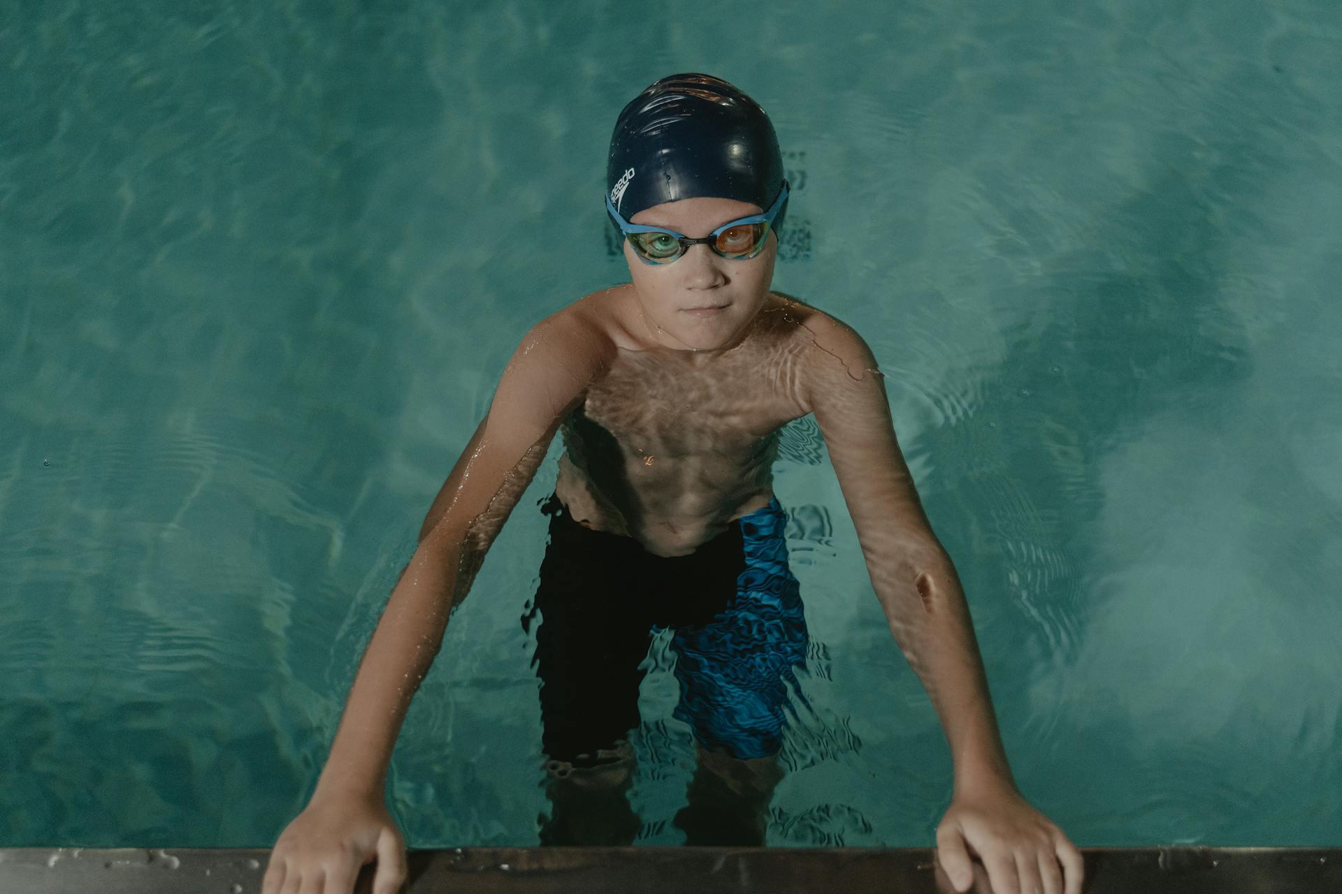 crianca na piscina com oculos de natacao