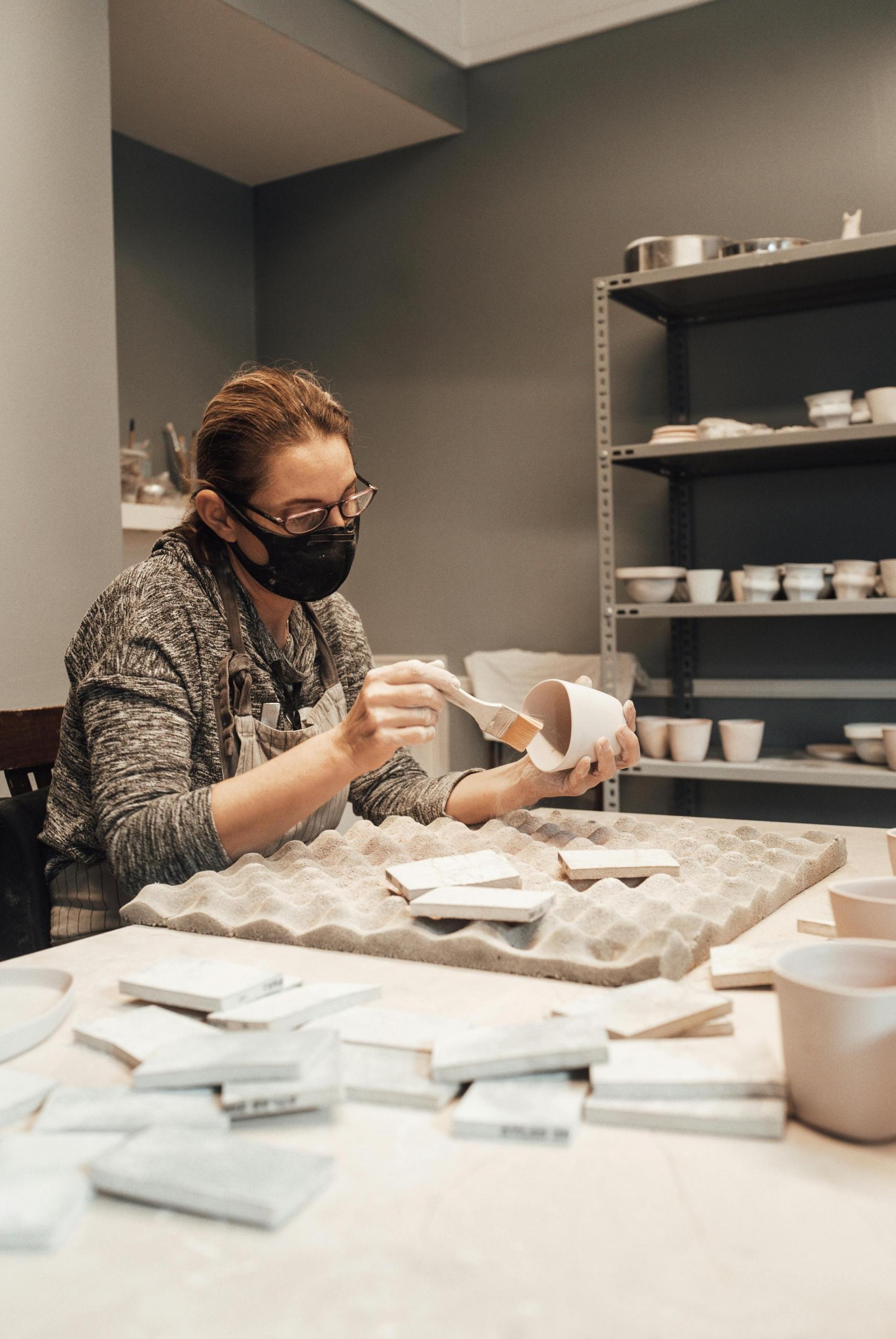 mulher num estúdio com peça cerâmica