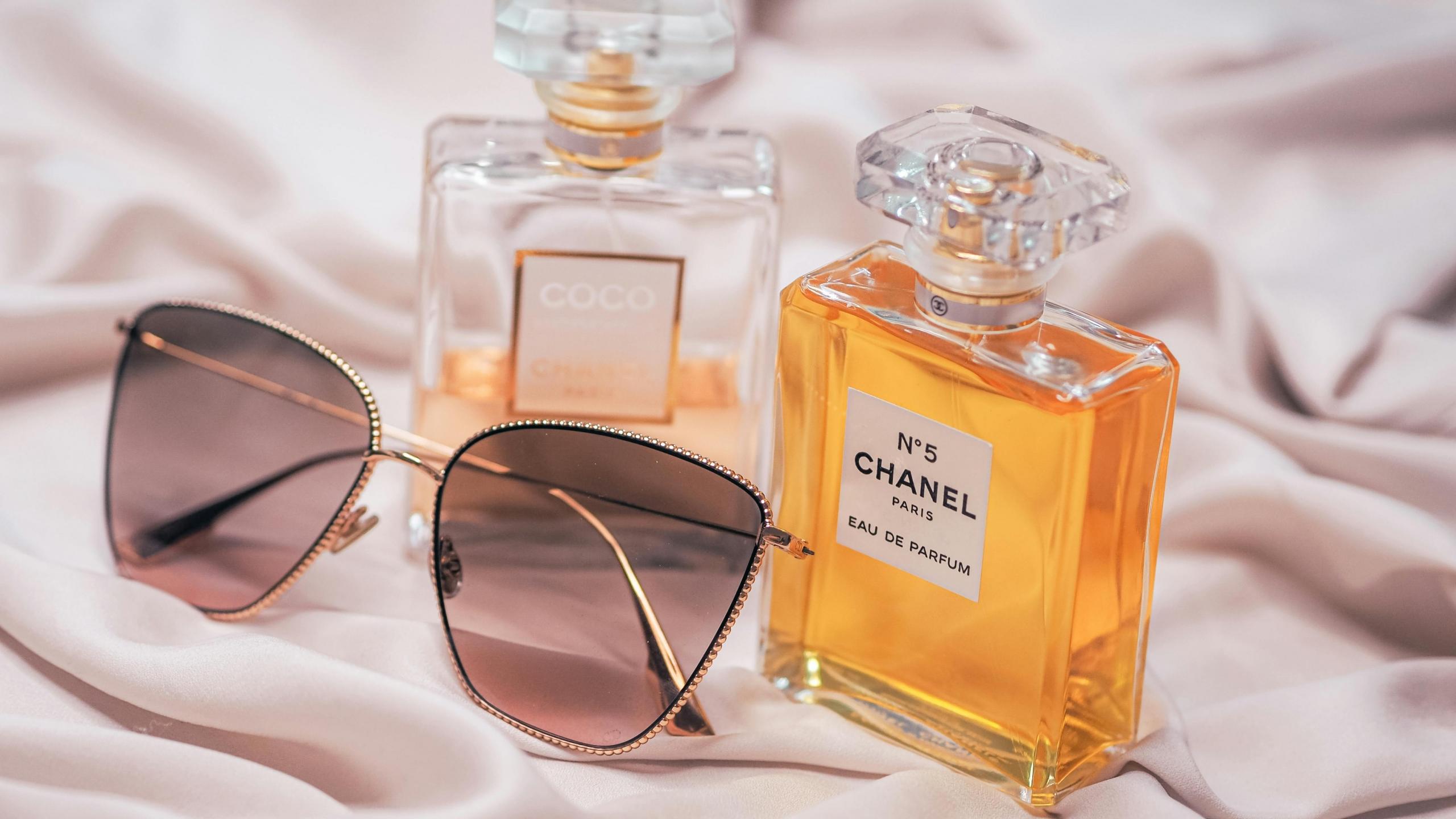 garrafas perfume e óculos de sol