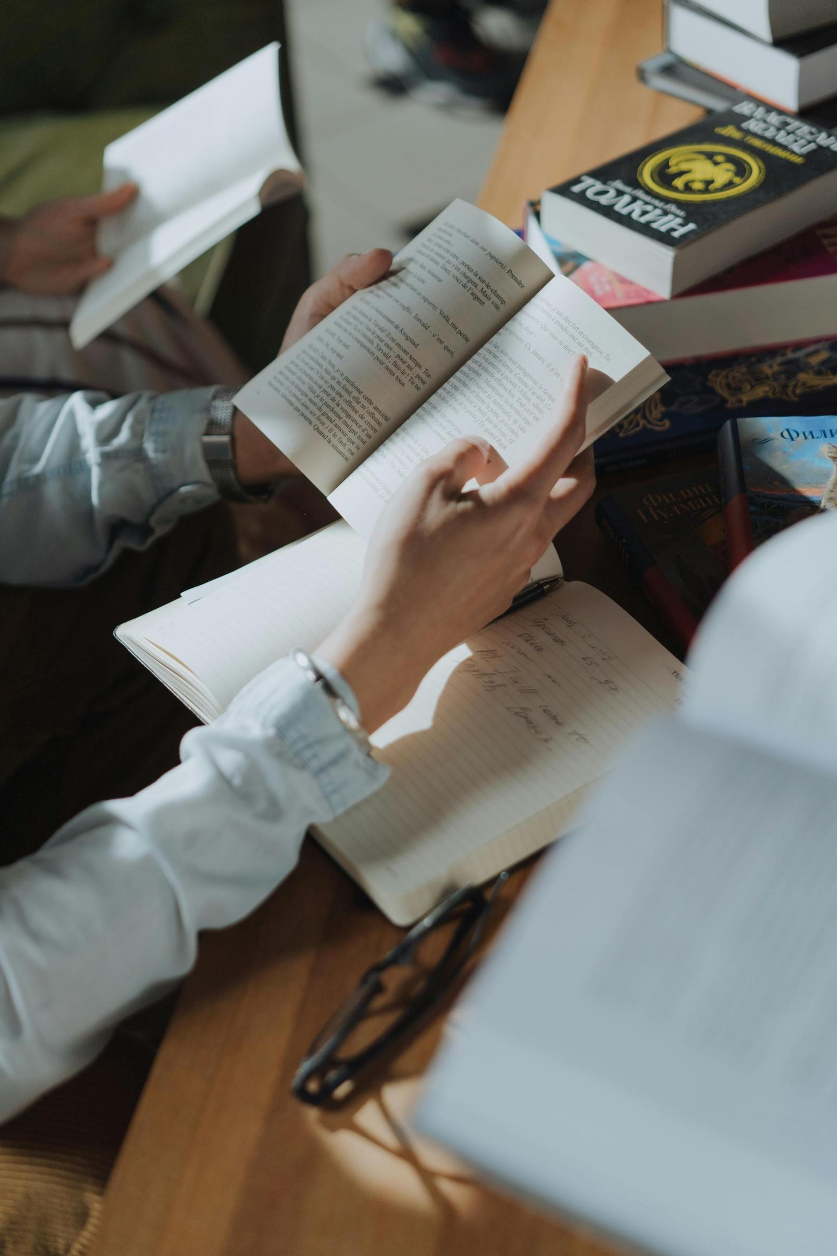 pessoa a segurar um livro num secretária