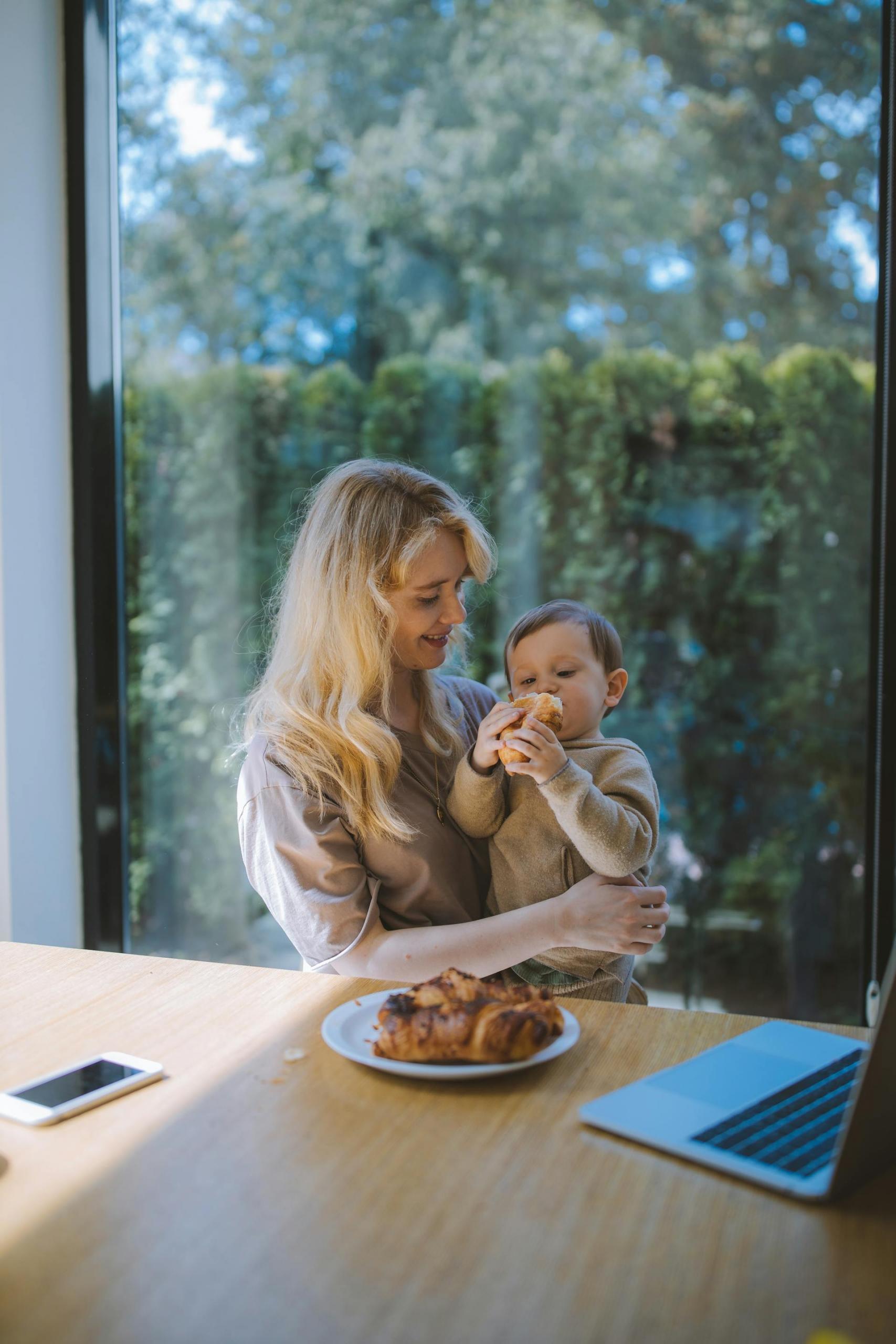 mãe com filho ao colo a comer