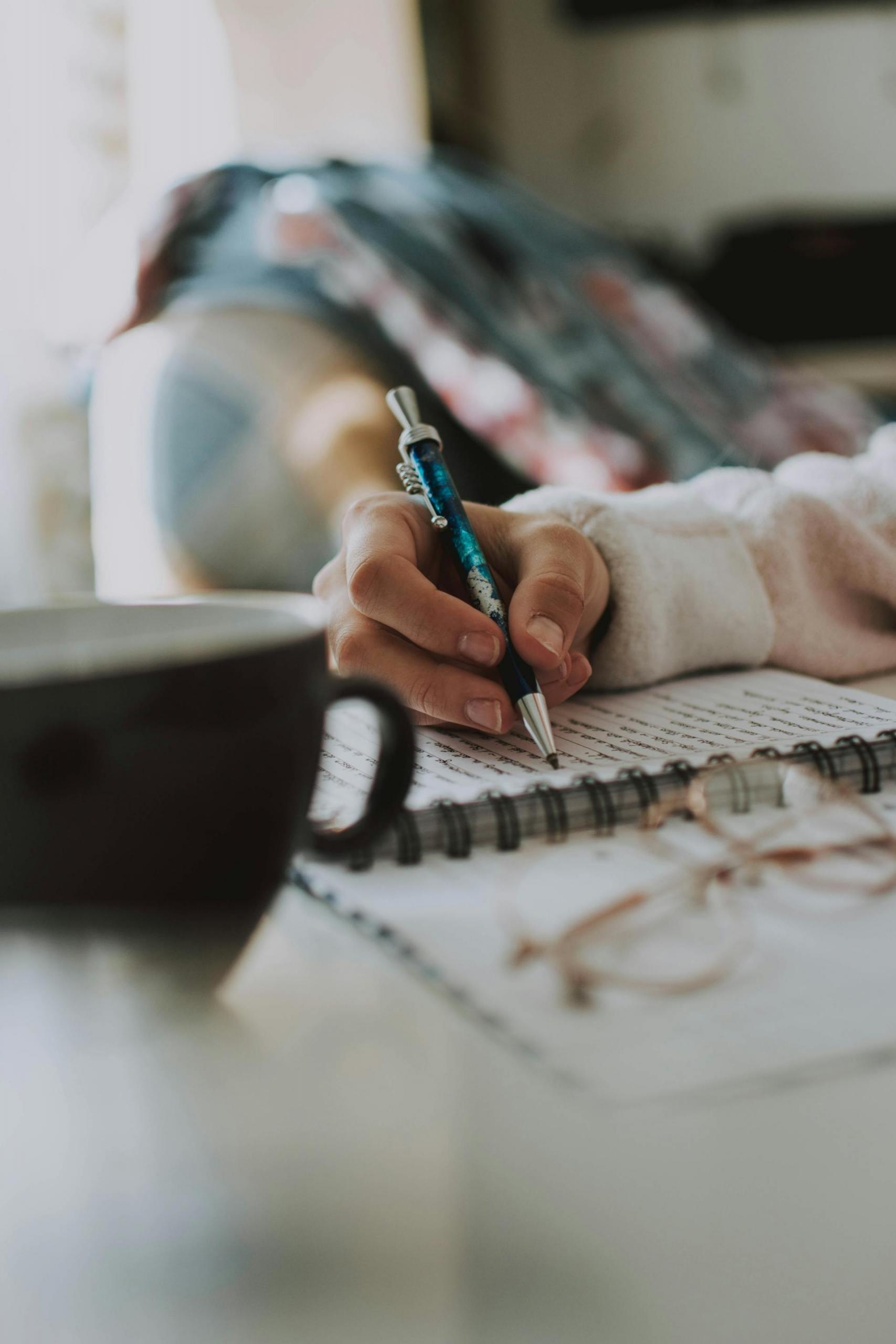mão de pessoa a escrever num caderno