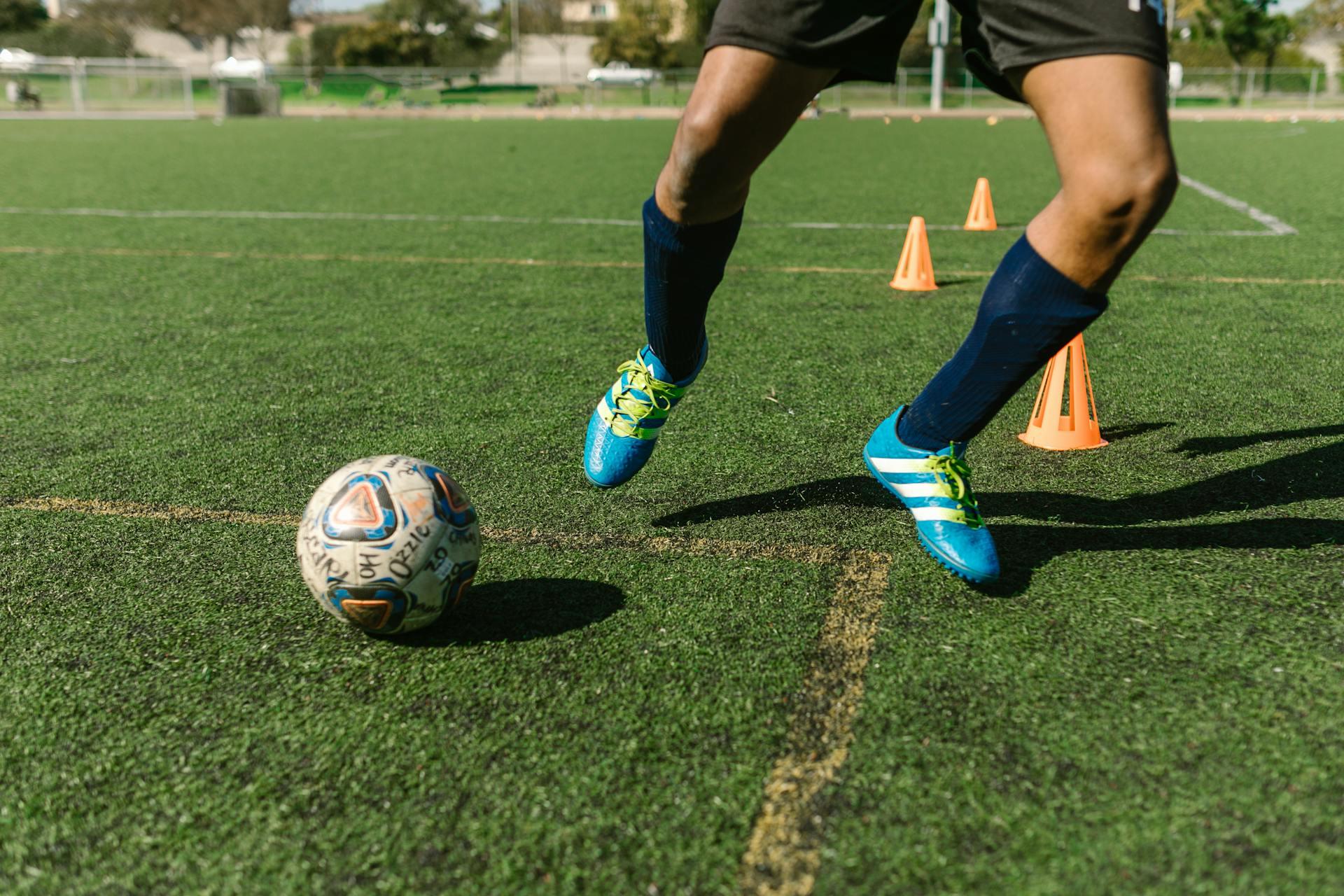 pés de jogador a driblar a bola