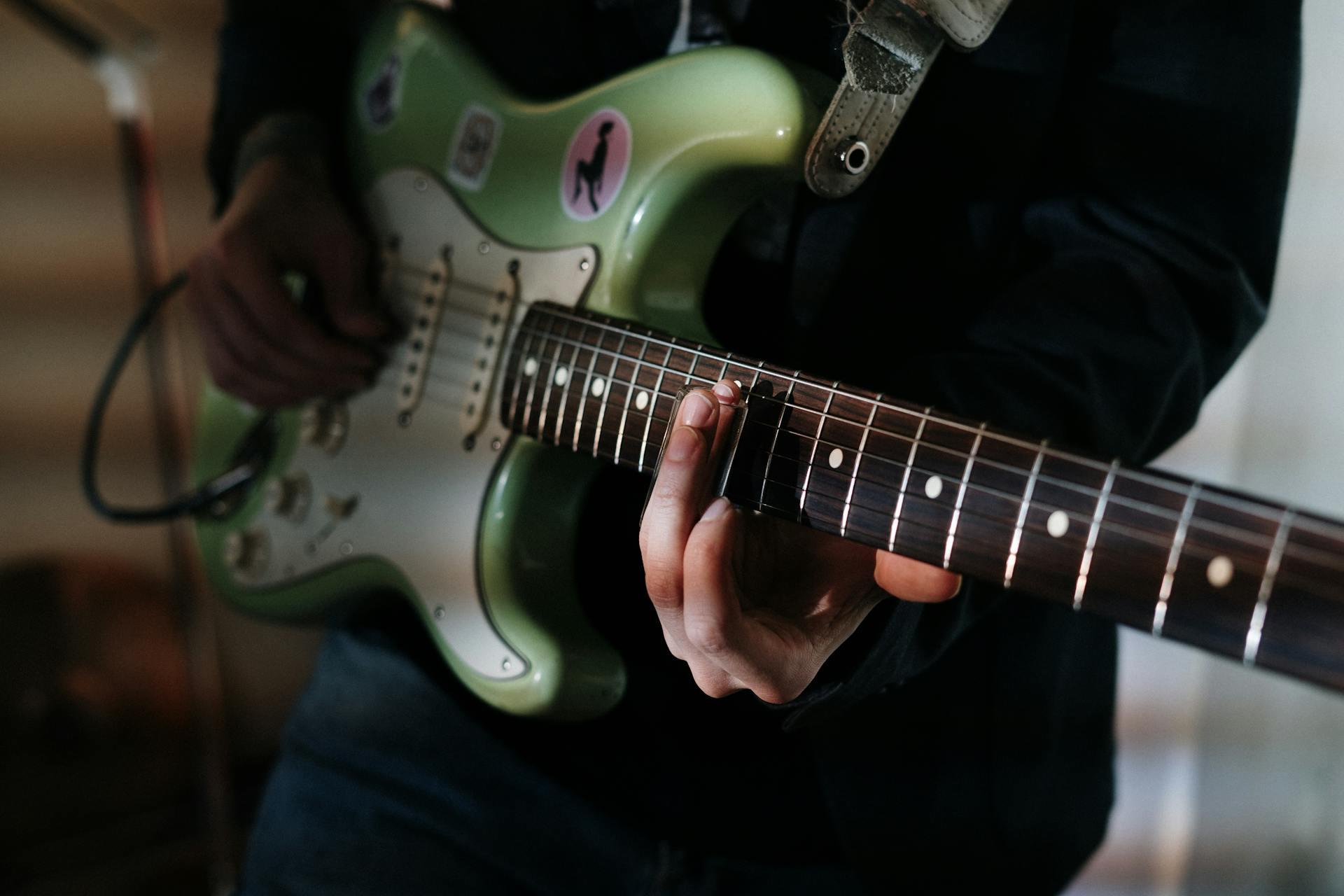 pessoa a tocar guitarra verde
