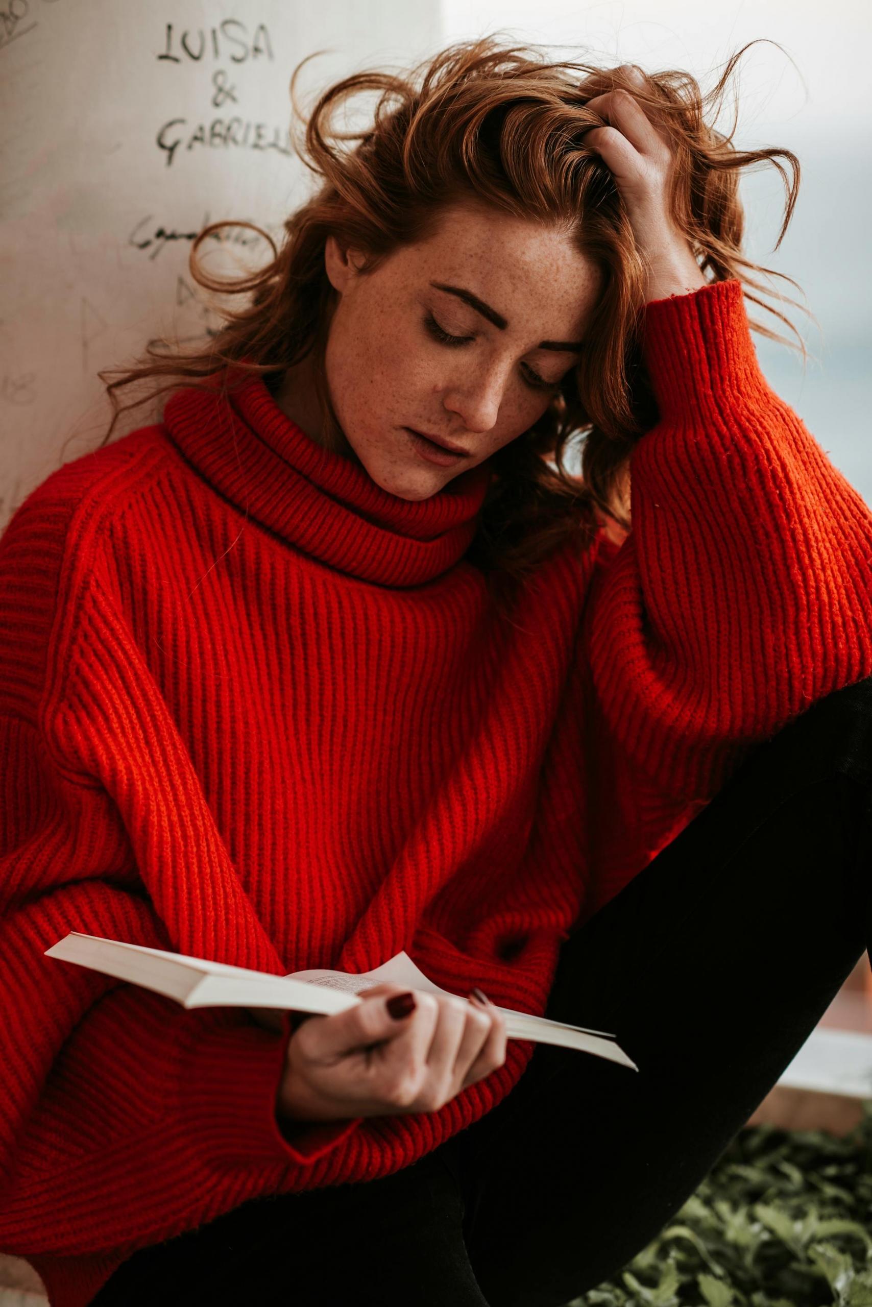 mulher de camisola vermelha a ler livro