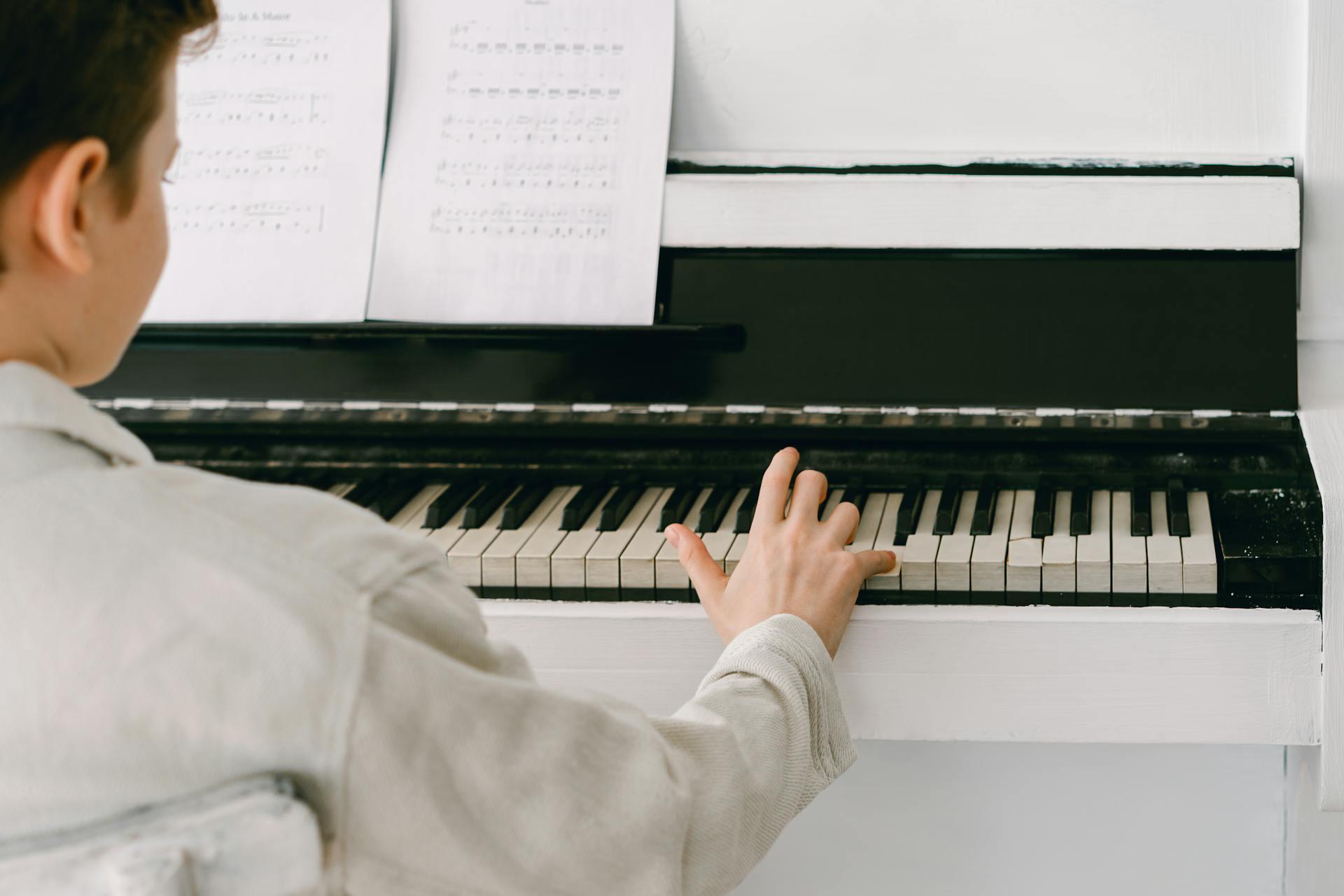 homem a tocar teclas de um piano