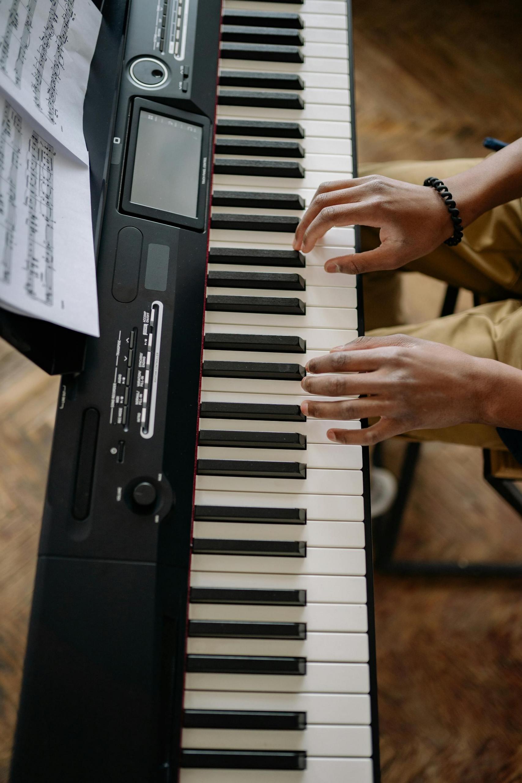 pessoa a tocar teclado do piano com as duas mãos