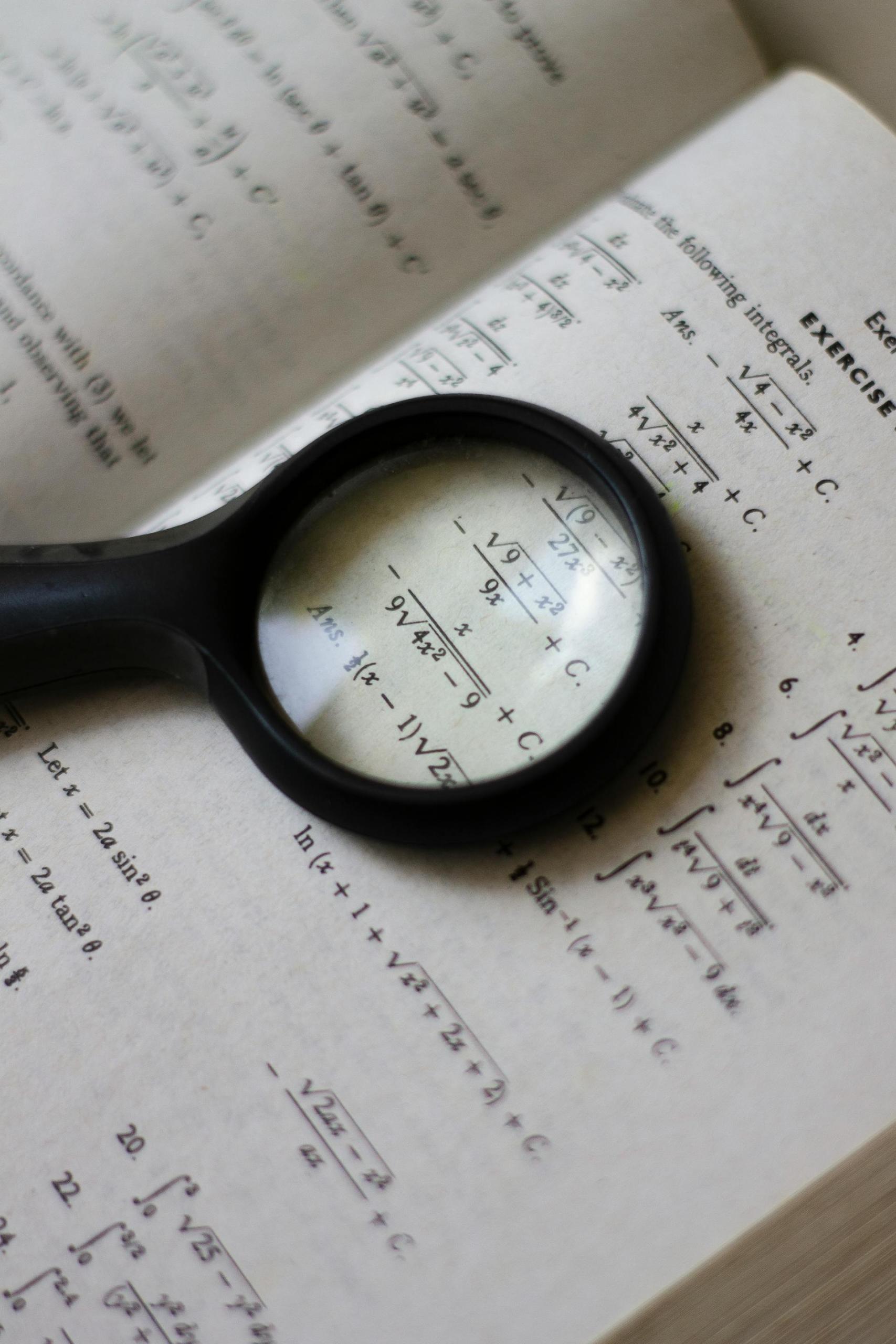 livro de matemática e lupa
