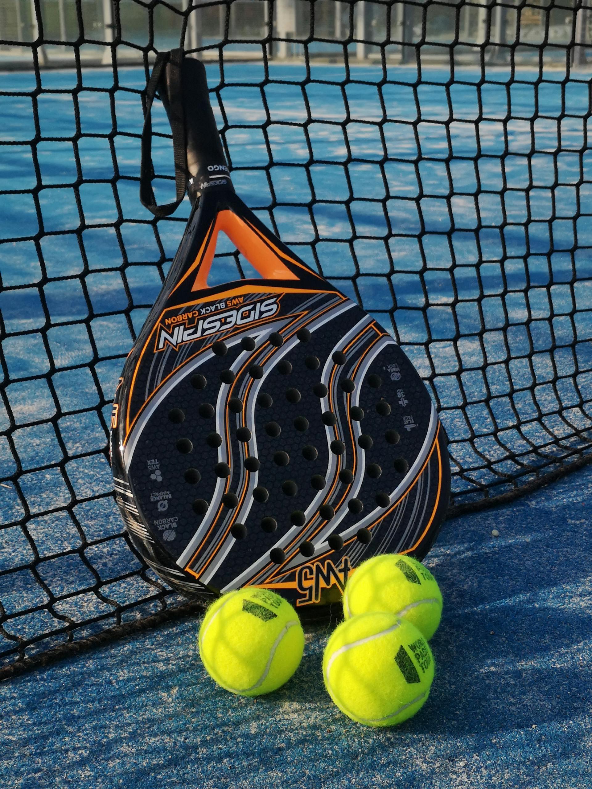 raquete de padel encostado a uma rede