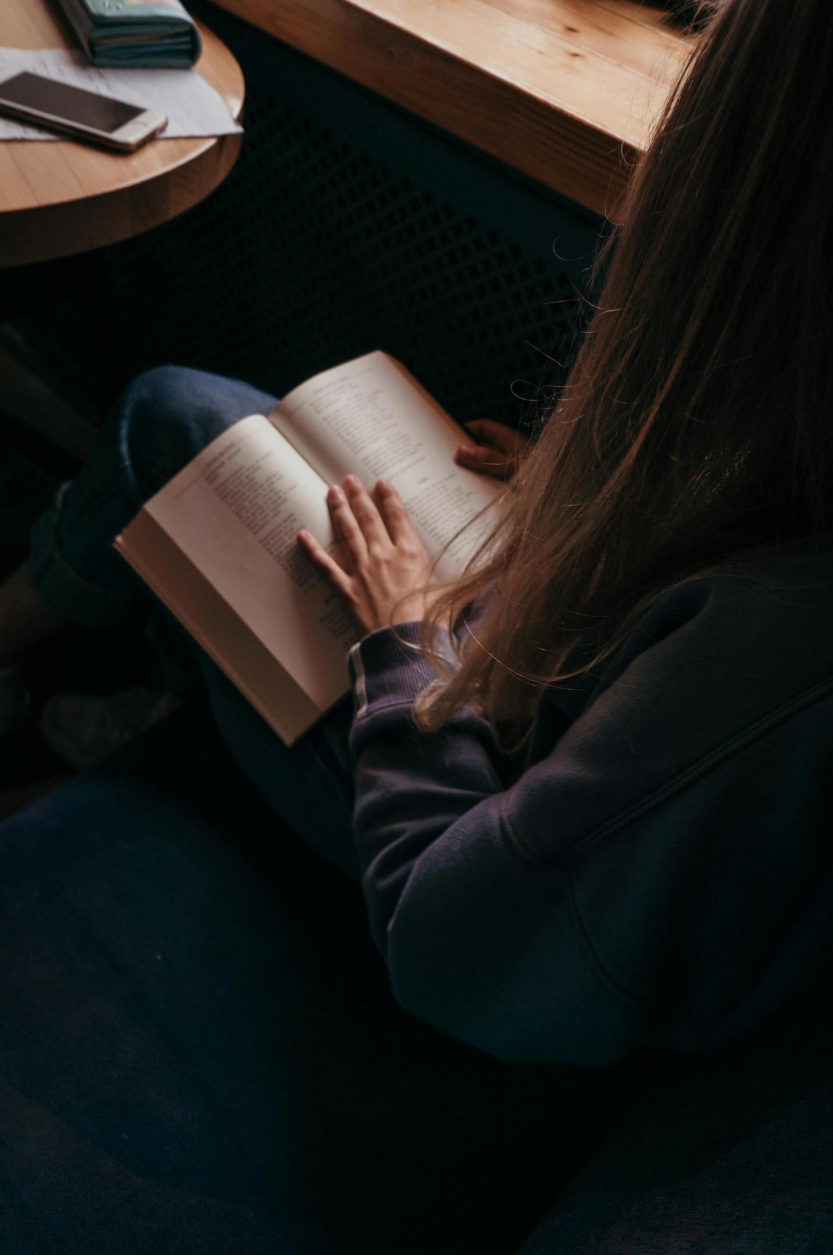 mulher com livro aberto no colo