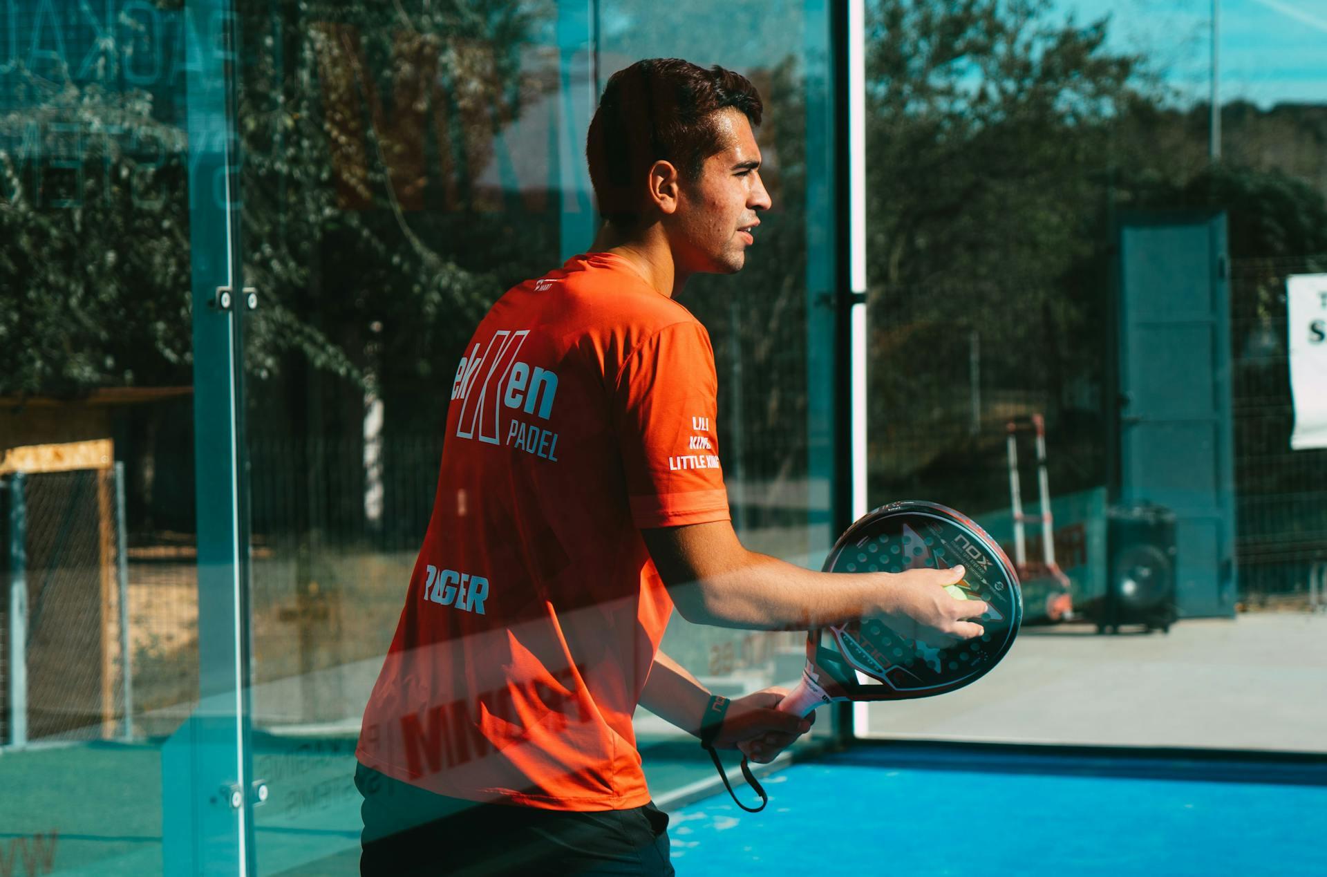 homem com raquete de padel na mão
