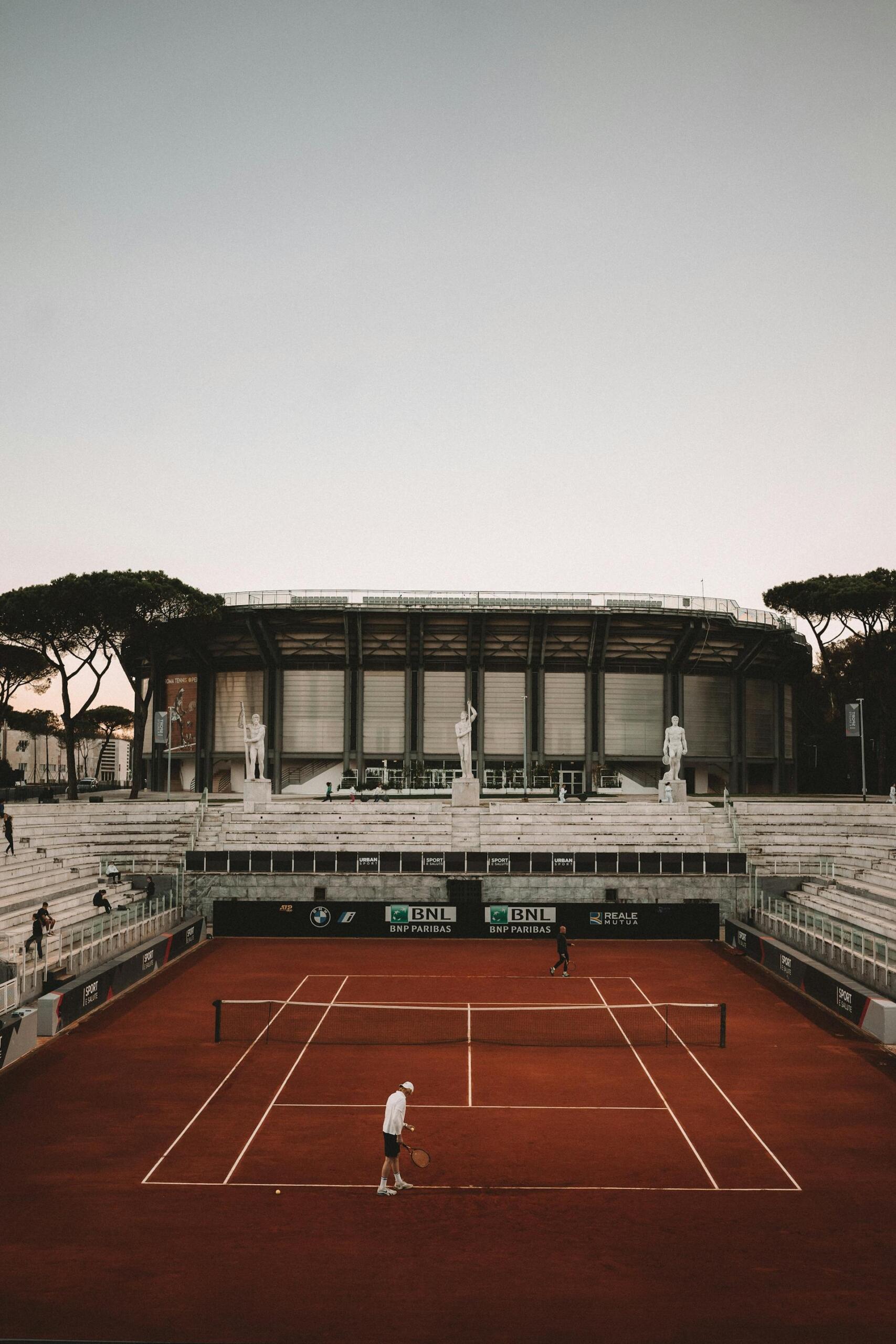 campo de ténis de terra batida com jogador no meio
