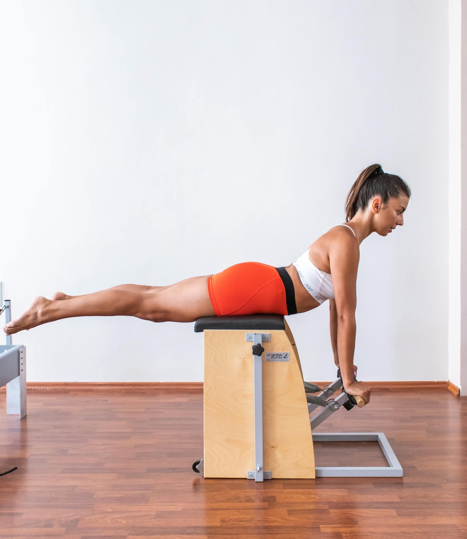mulher a equilibrar-se em aparelho de pilates