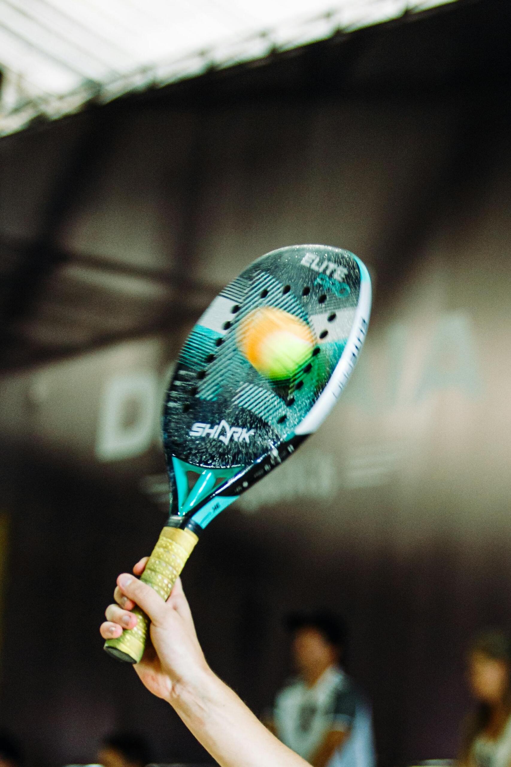 mão a segurar raquete de padel com bola