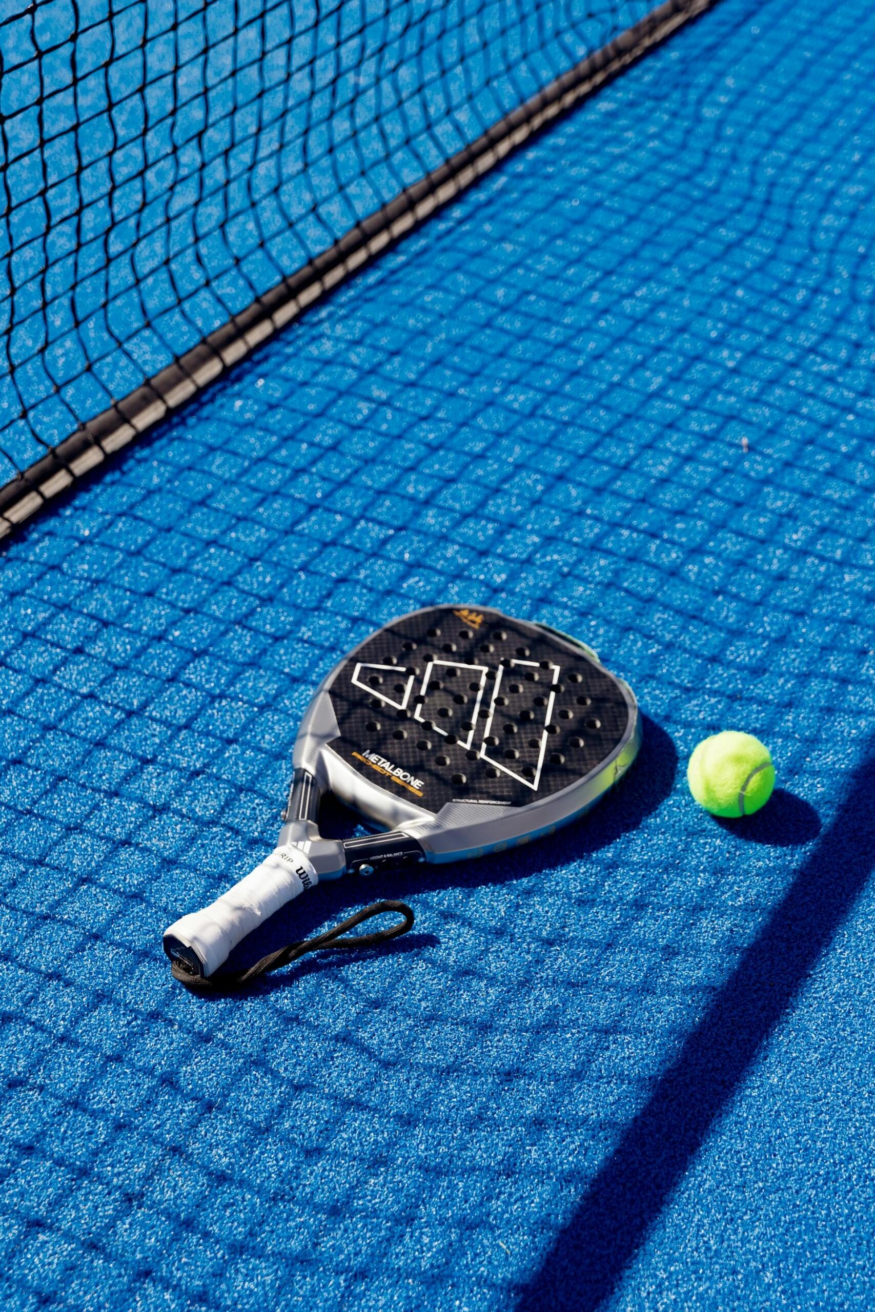raquete de padel no chão do campo
