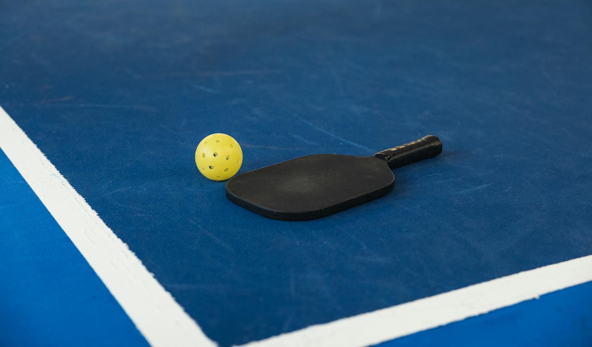 raquete de padel preta no chão
