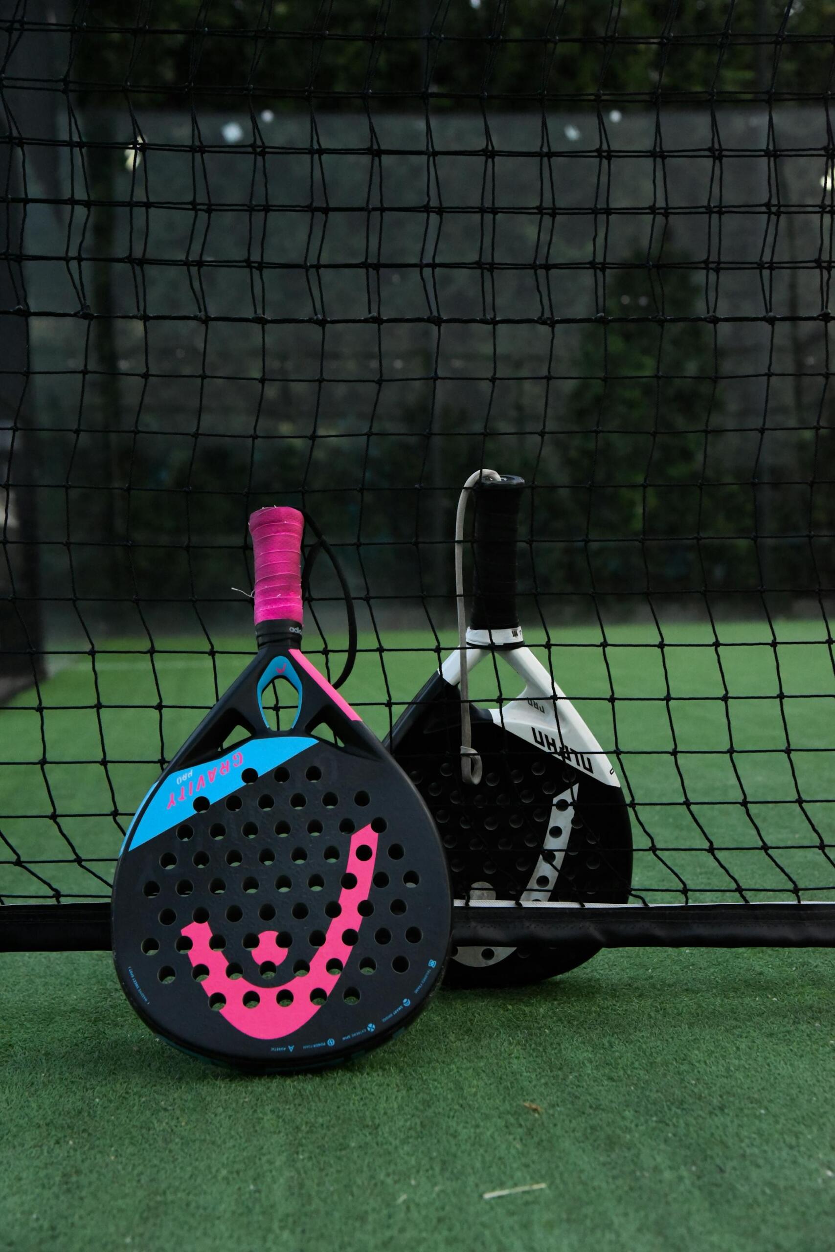 raquetes de padel encostados à rede