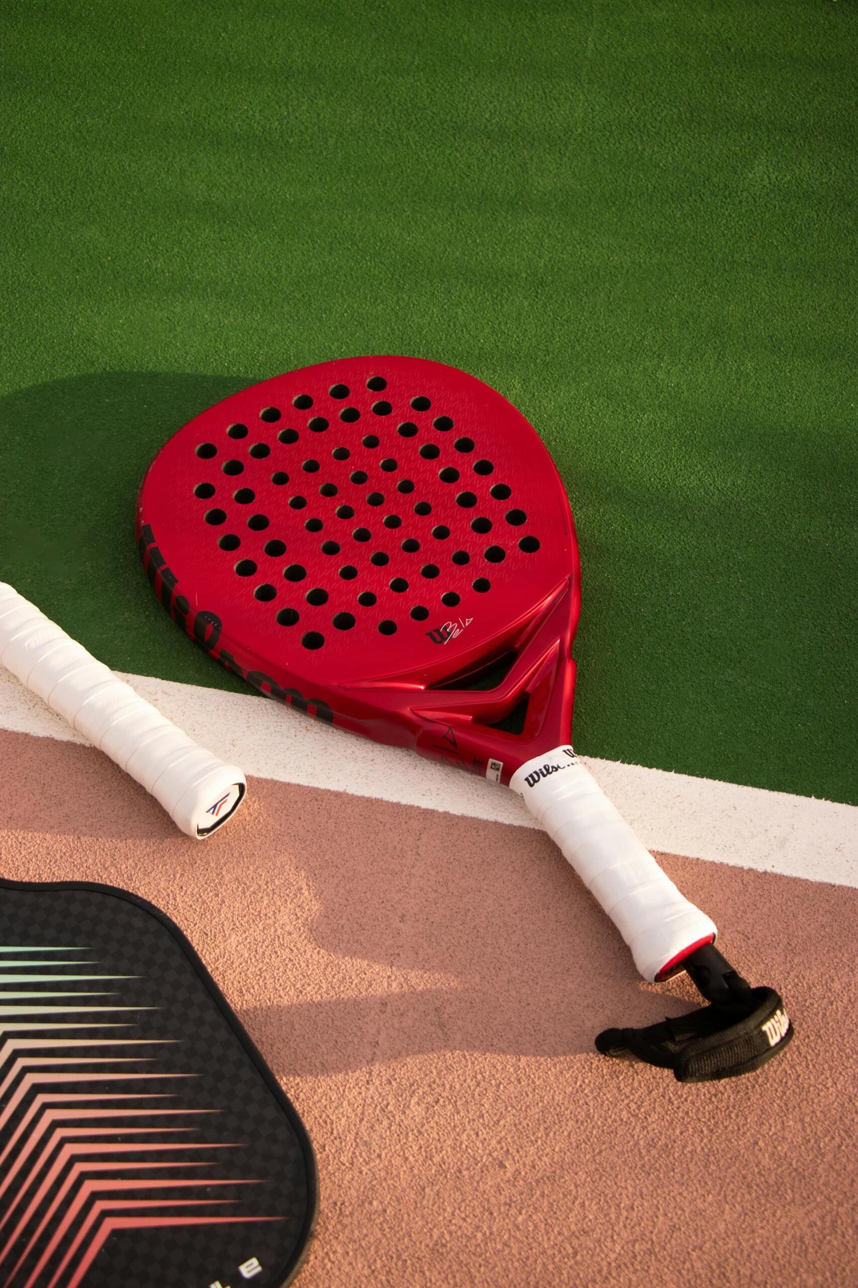 raquete de padel vermelha no campo