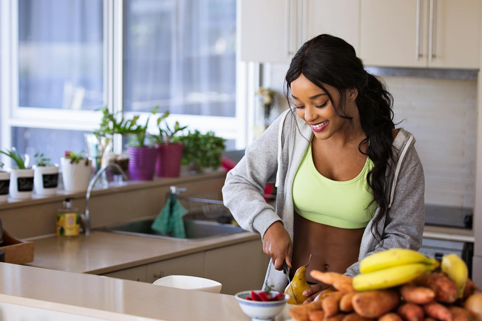 mulher a cortar fruta na cozinha