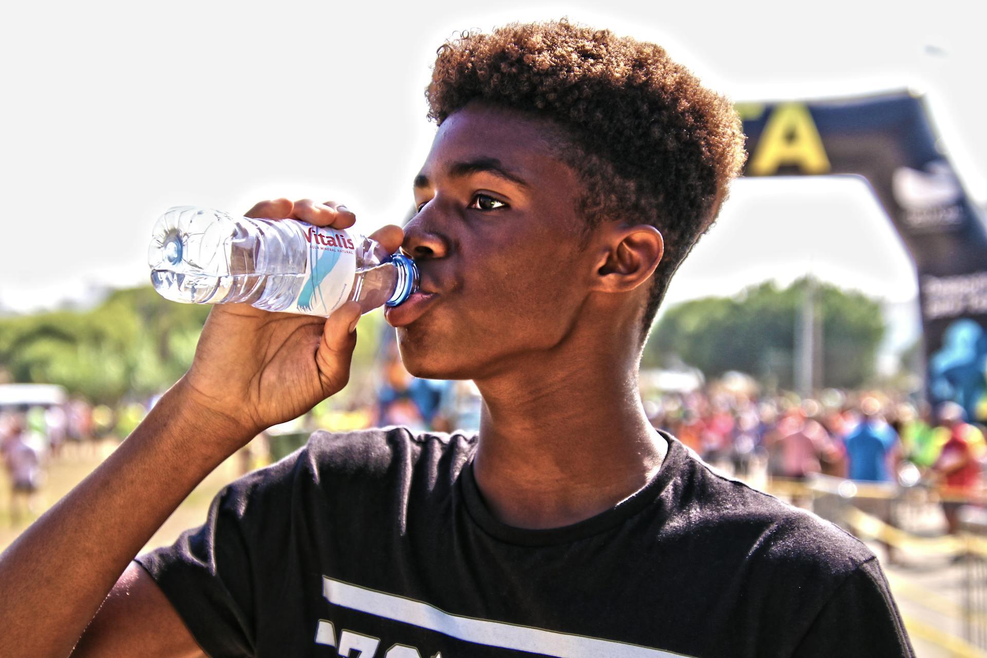 jovem a beber de uma garrafa de água