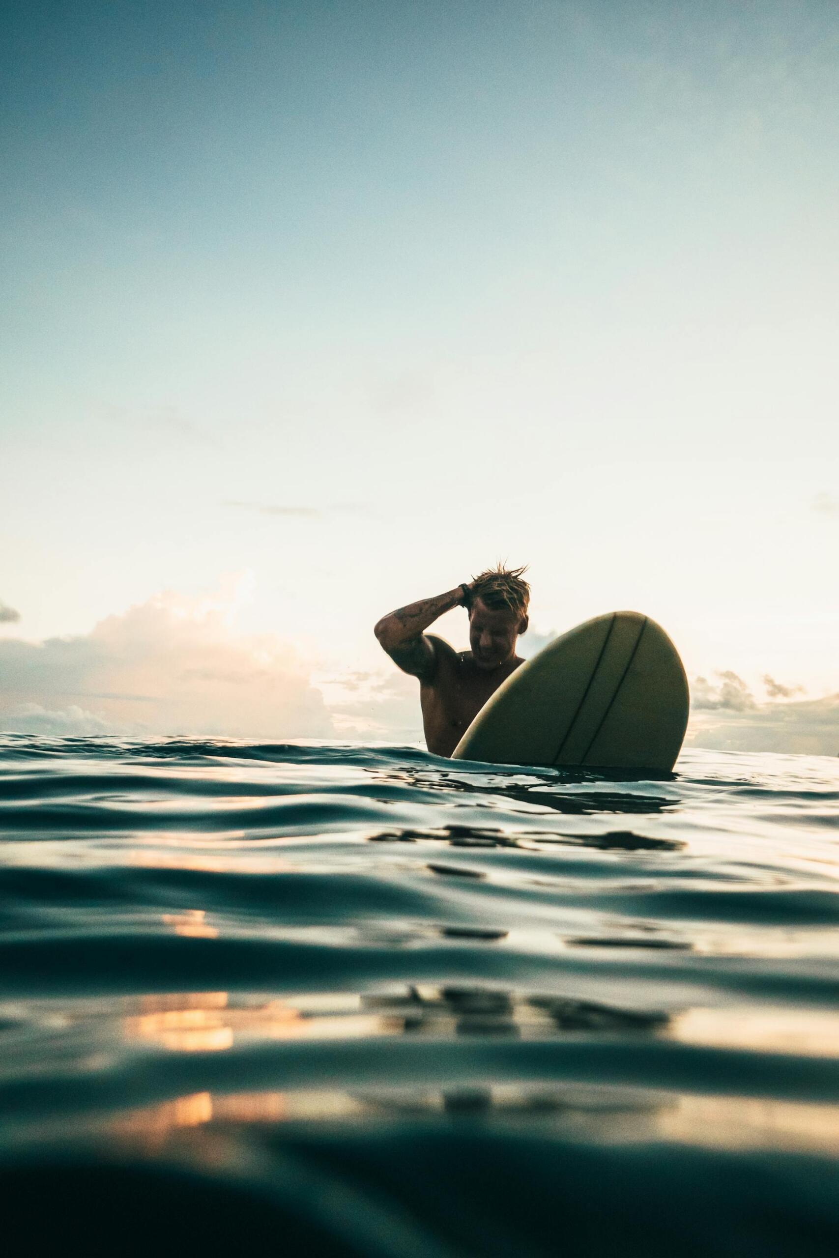 surfista com prancha dentro do mar